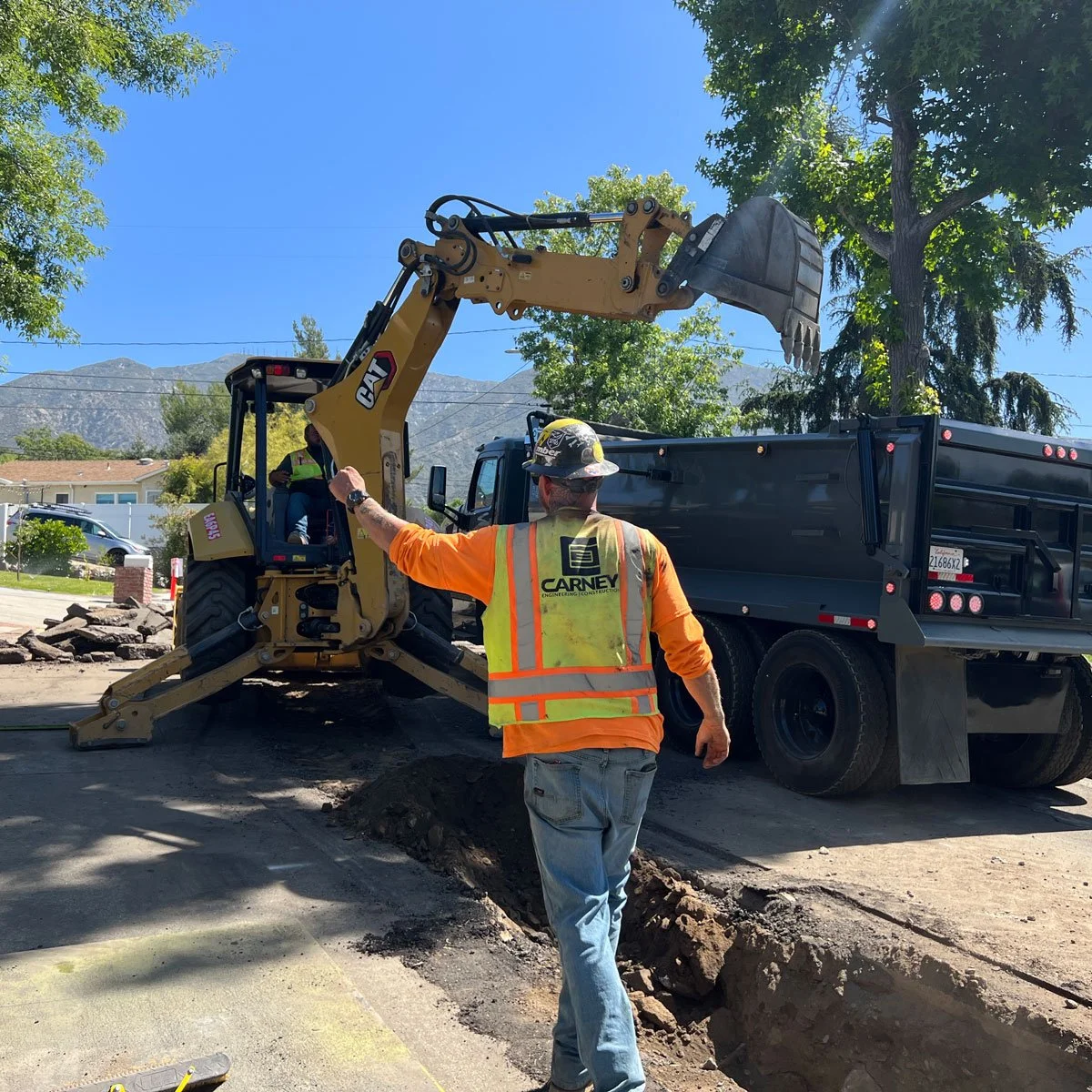 carney engineering construction team digging trench with backhoe