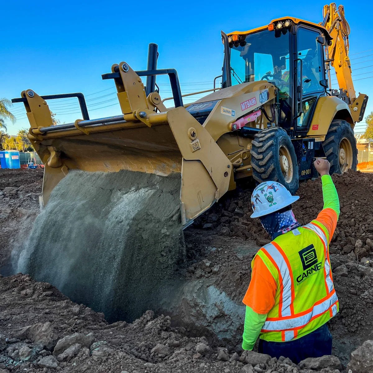 carney engineering construction team filling in trench with backhoe