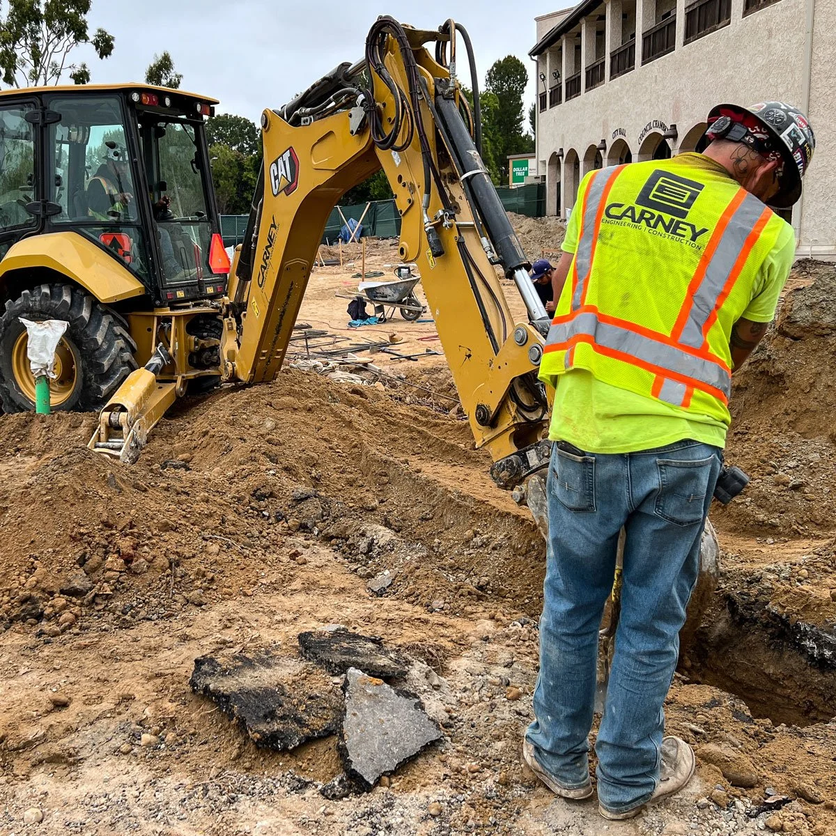 carney engineering construction installing underground utilities with backhoe