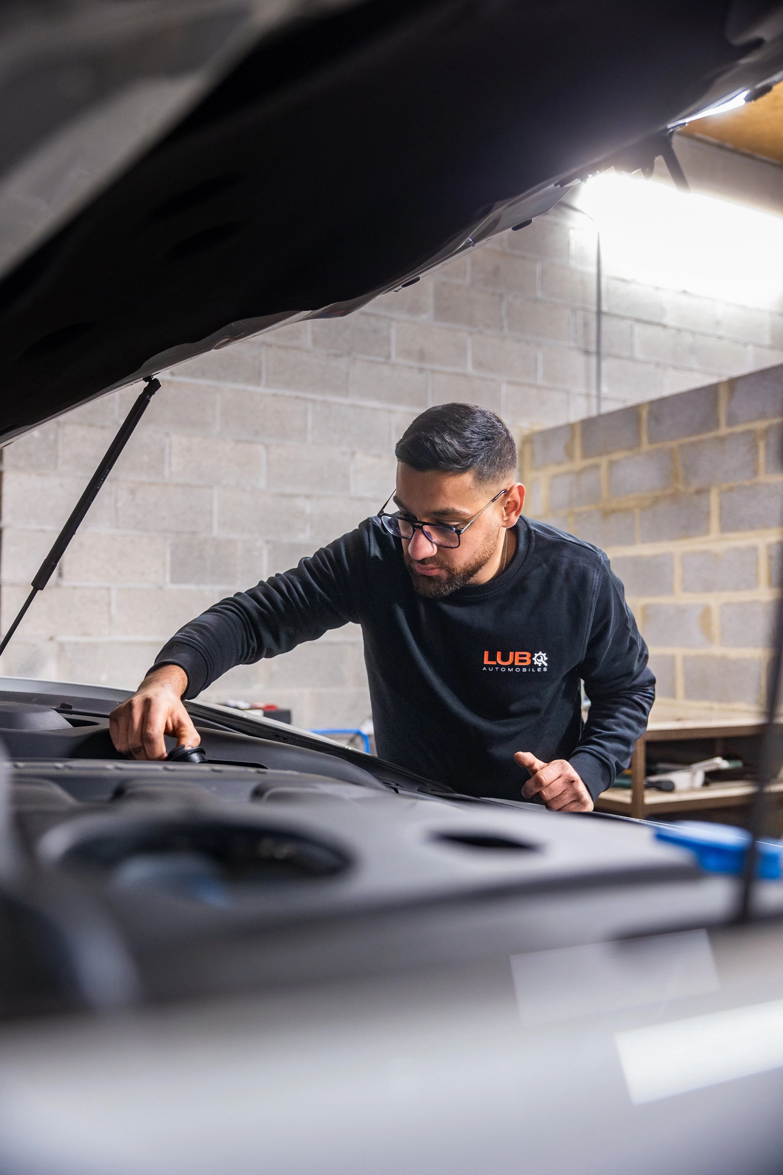 Un mécanicien inspecte le moteur d'une voiture dans un atelier à Verviers
