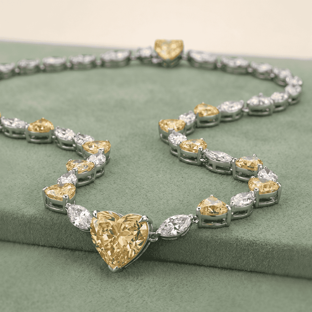 A diamond and gold heart-shaped necklace displayed on a green fabric surface.