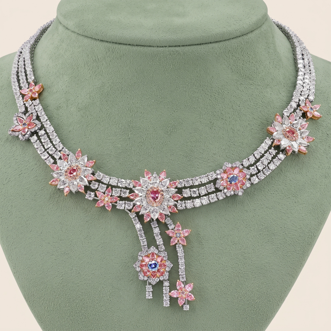 Elegant diamond necklace with pink and multicolored flower-shaped gems displayed on a green bust form.