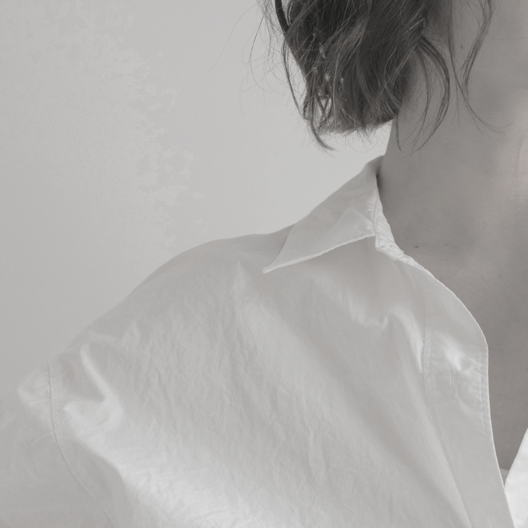 Close-up of one person applying a small tattoo to another person's hand using a pin or needle.