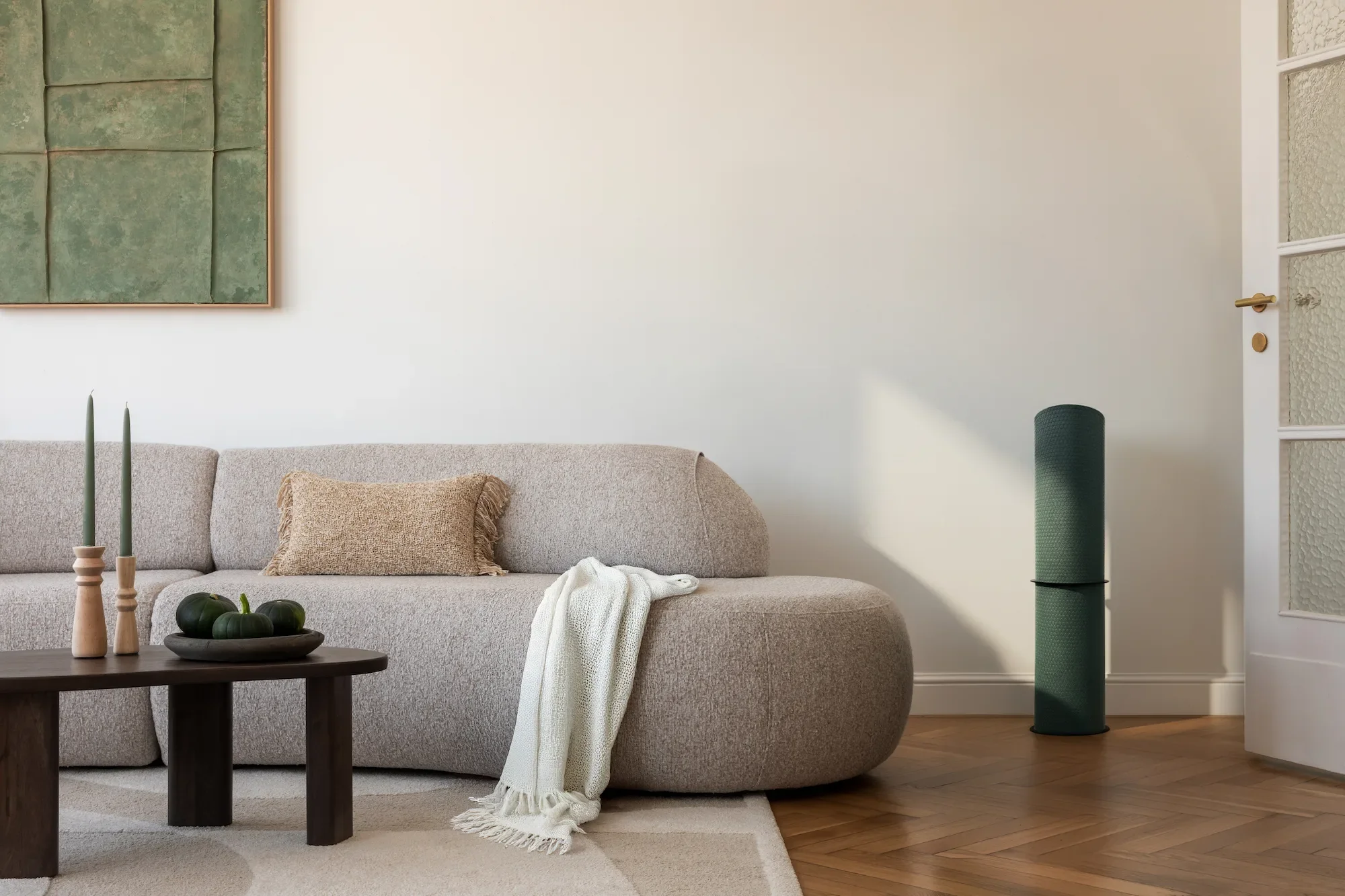 Minimalistisches Wohnzimmer mit runder Couch und MatBase Yogamattenhalterung auf dem Boden