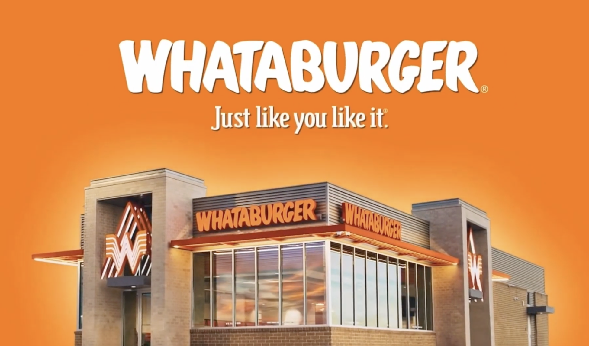 Exterior of a Whataburger restaurant with bright orange background and signage, featuring large windows and a modern design.