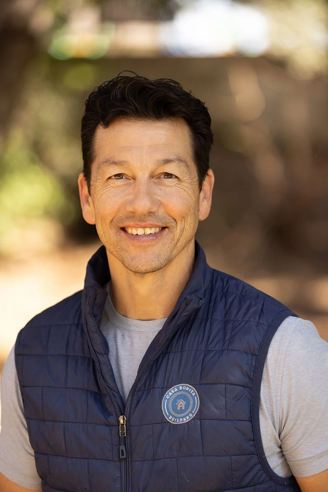 Jack Ramirez, founder of Casa Bonita Builders, wearing branded vest outdoors in Pasadena, CA, representing a licensed general contractor specializing in custom homes and remodels.