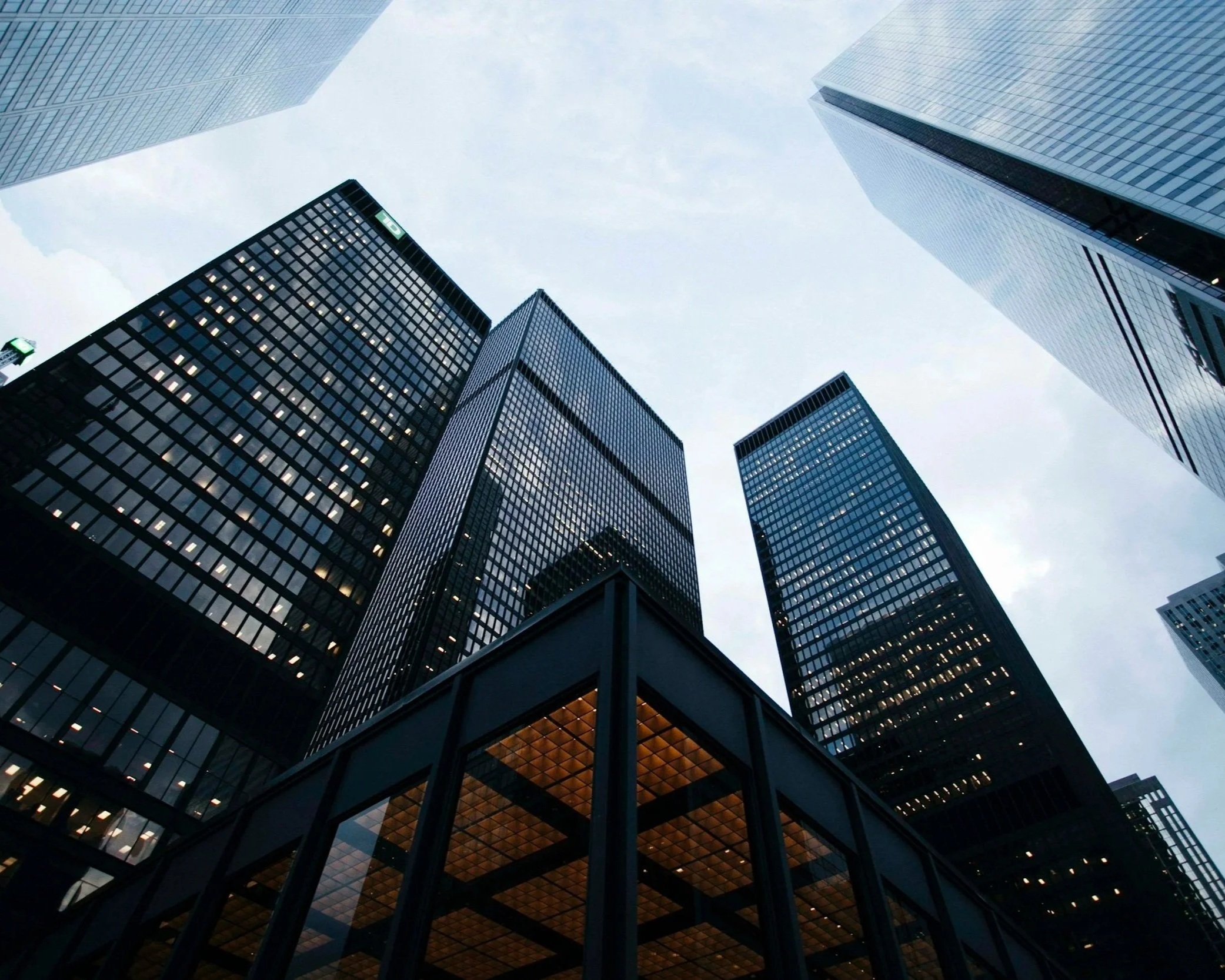 View of tall modern glass skyscrapers from the ground looking up at the sky.