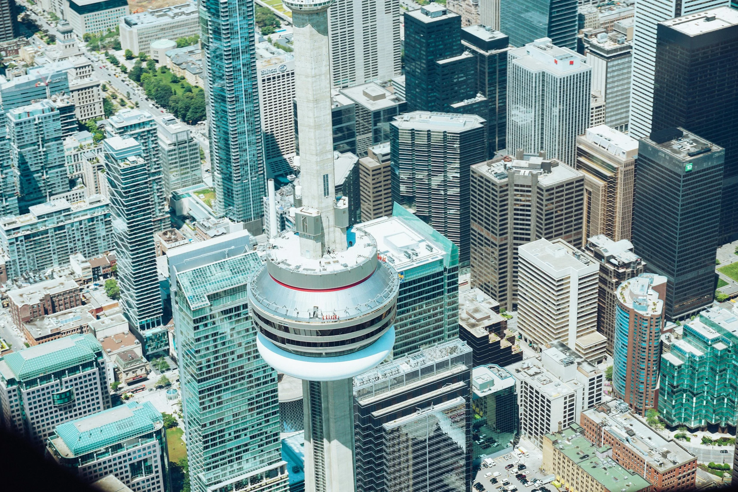 Aerial view of a city skyline with tall skyscrapers, including the CN Tower, in Toronto, Canada.