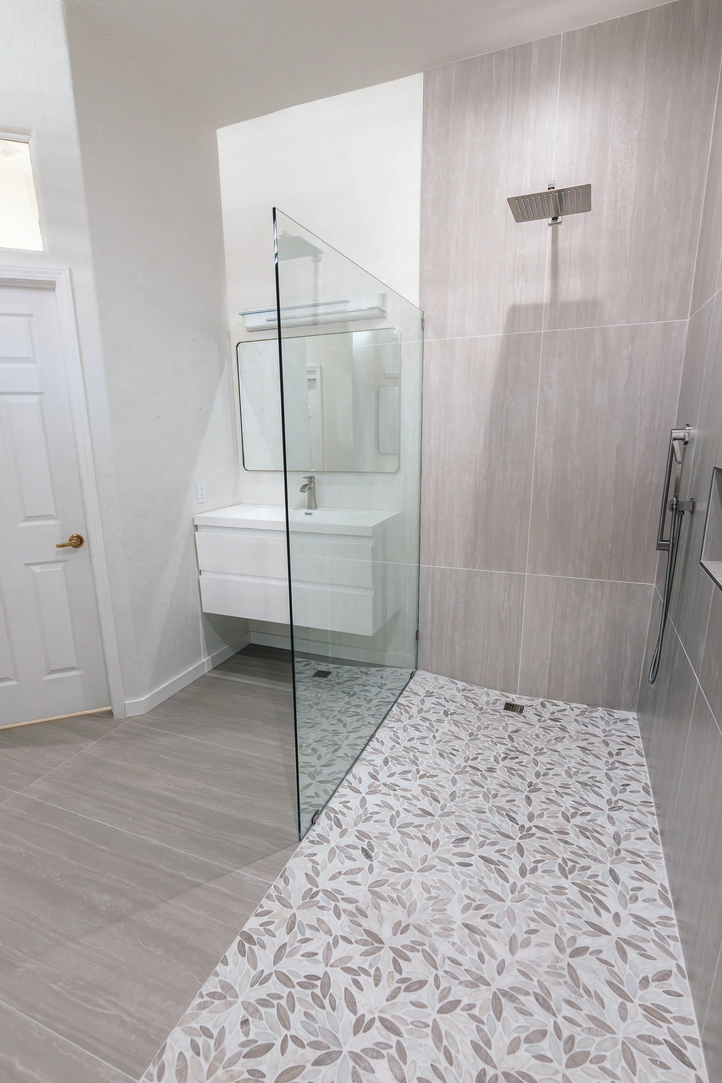 Modern bathroom with a walk-in shower and a floating vanity with a mirror.