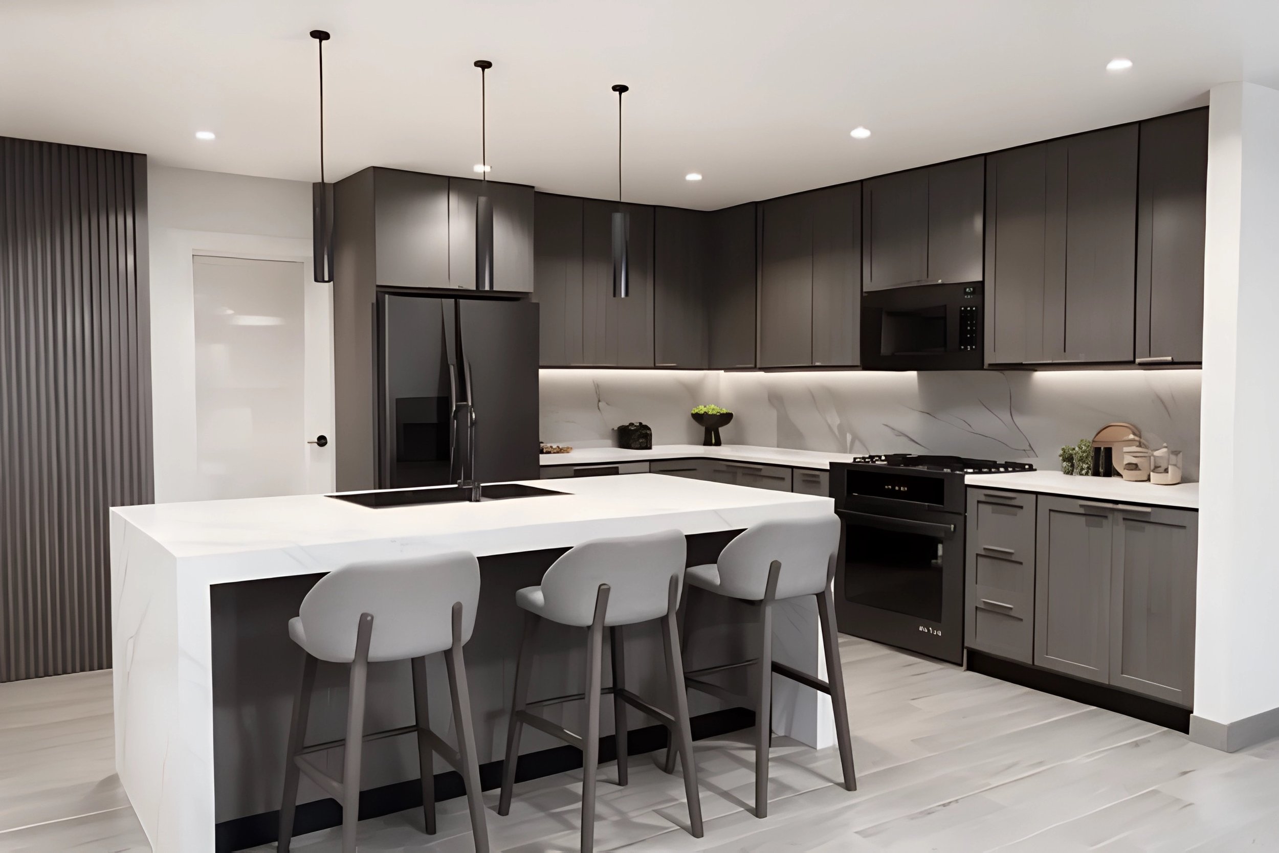 Modern kitchen with black cabinetry, white marble countertops, a kitchen island with three bar stools, black appliances, and pendant lighting.