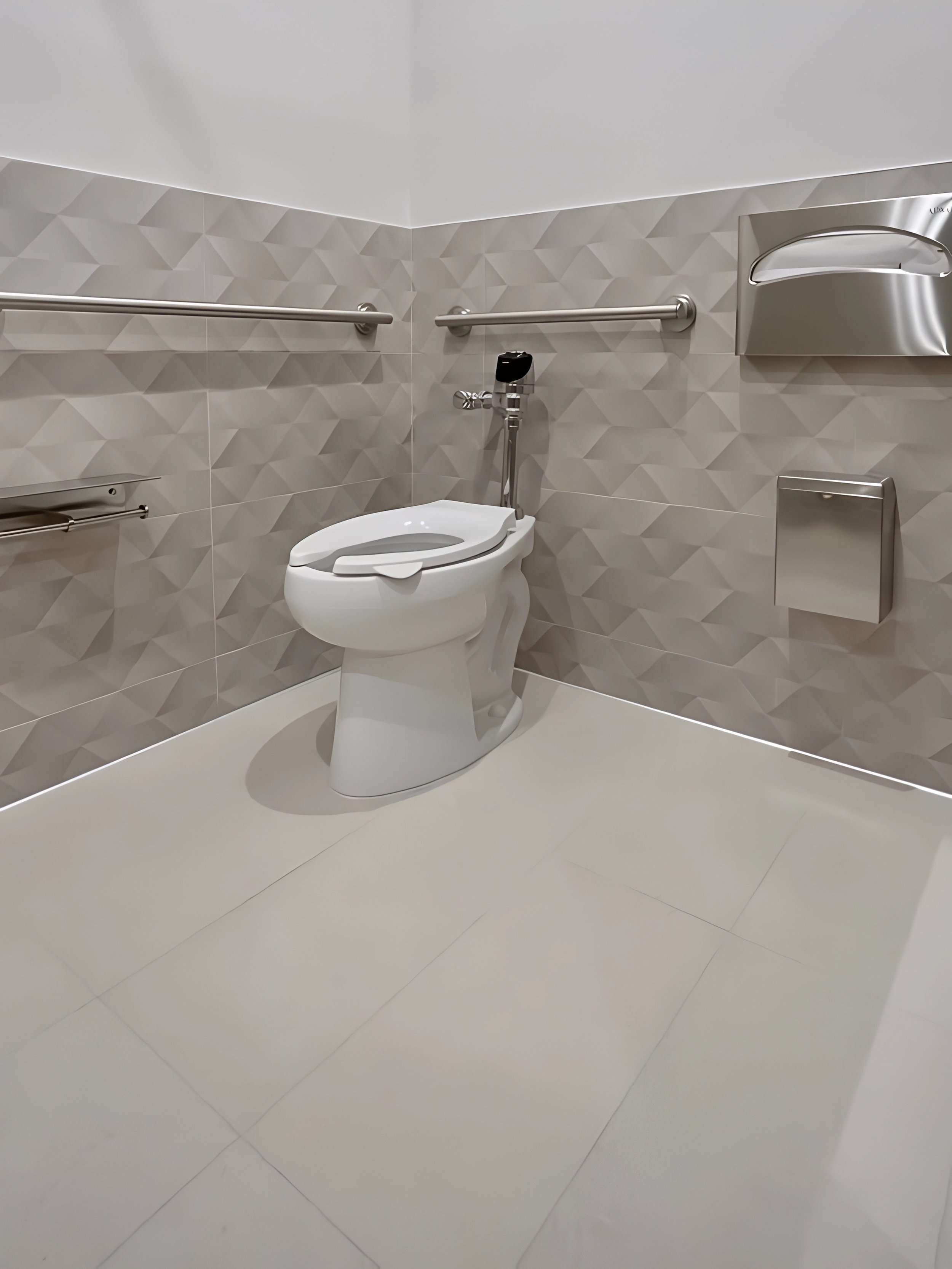 Accessible bathroom with a toilet, horizontal grab bars, a toilet paper dispenser, and a trash bin.