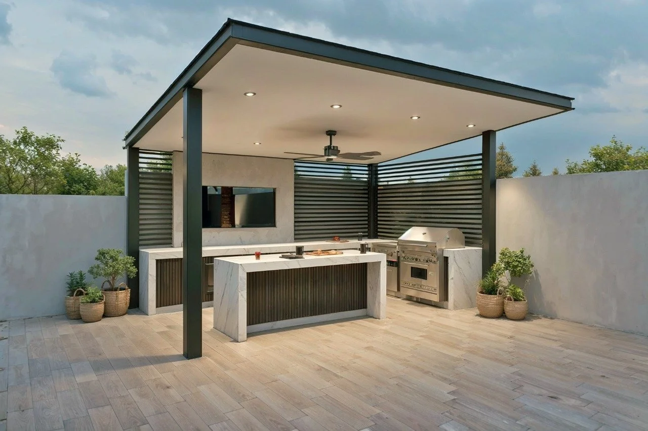 Outdoor modern kitchen with a covered patio, stainless steel grill, countertop, and potted plants in baskets.