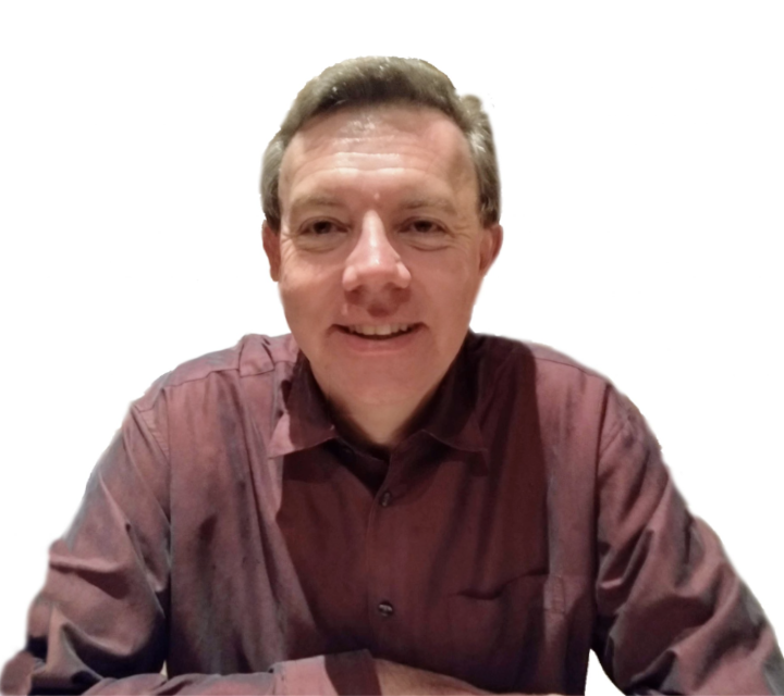 A man smiling and wearing a maroon button-up shirt, sitting against a plain white background.