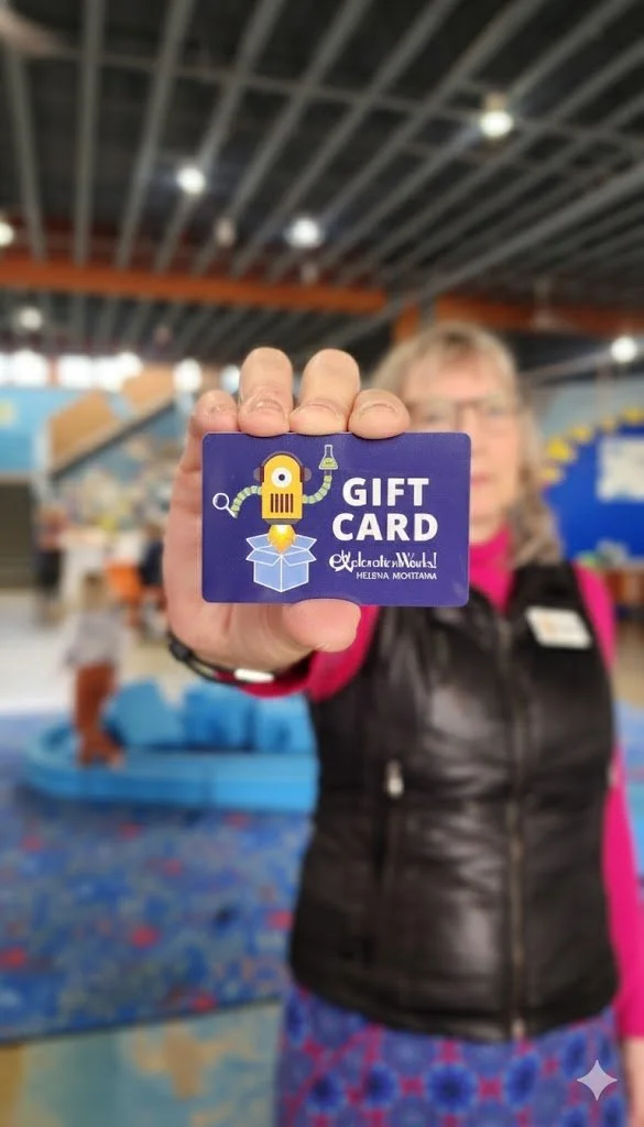 Person holding a purple gift card with a robot illustration in an indoor setting.