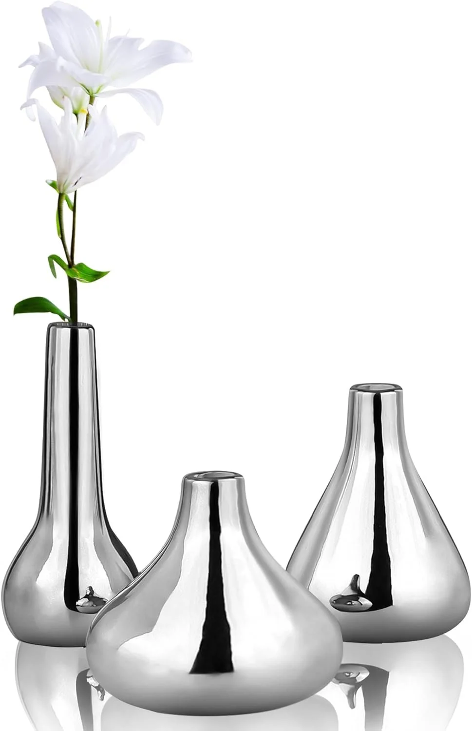 Three shiny silver vases, with one holding white lilies.