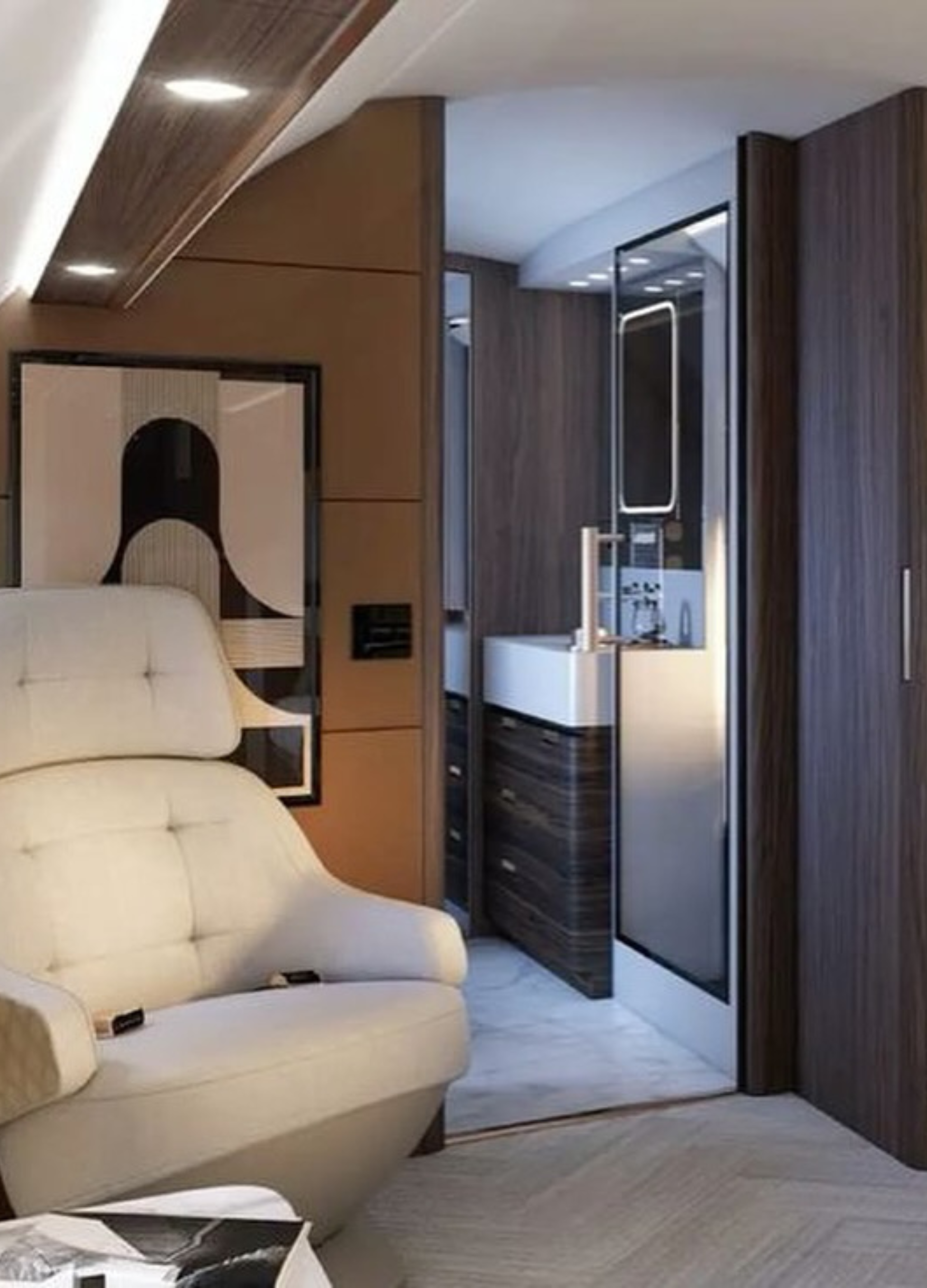 Modern hotel room with beige sofa, abstract wall art, wooden accents, and a mini fridge.