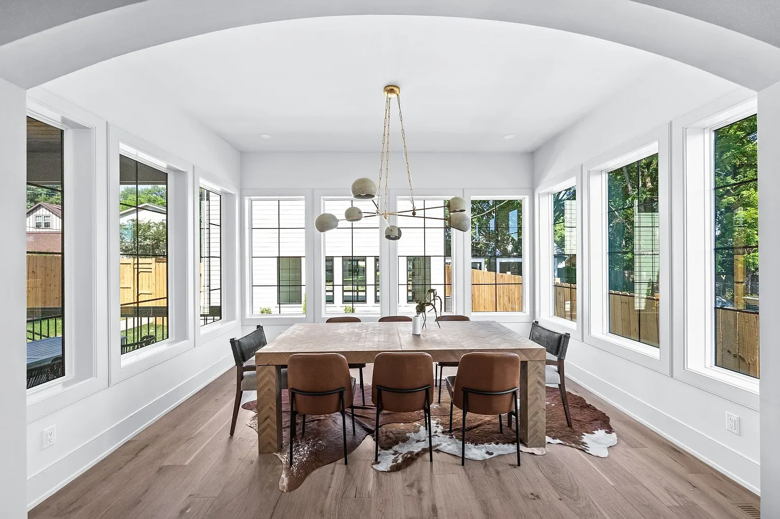 Arch opening to dining room that is surrounded by windows