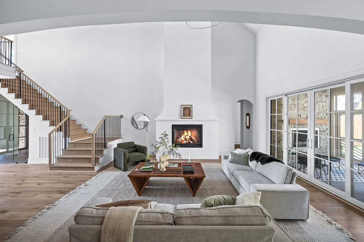 View from kitchen island looking into living room with custom archistone fireplace 
