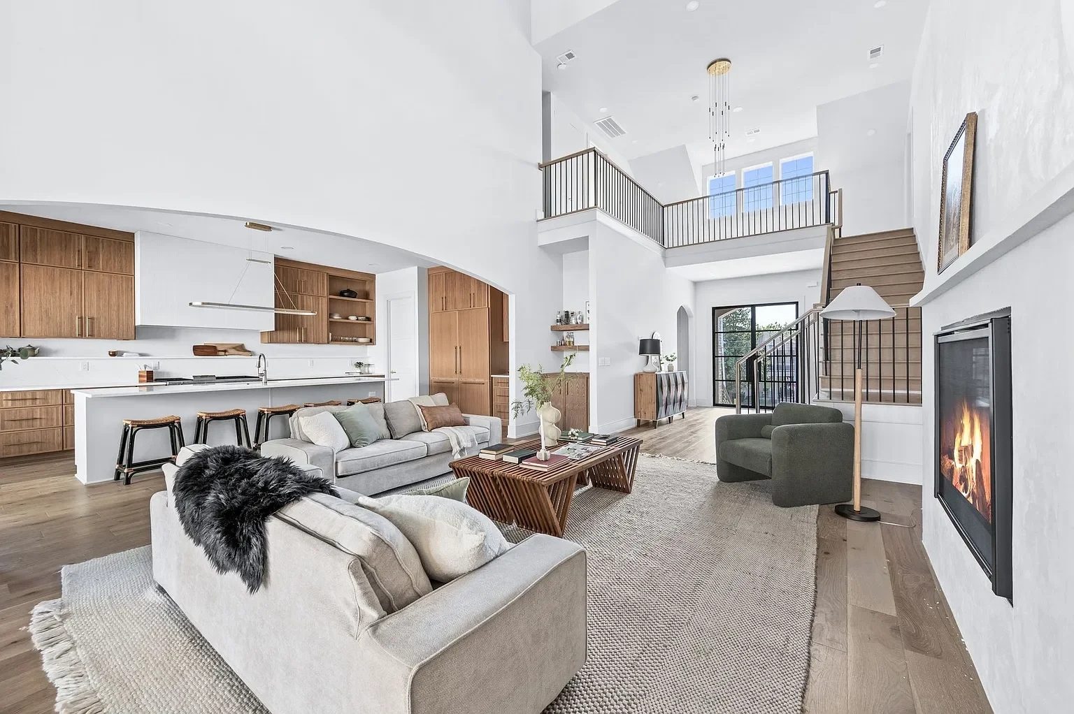 View from primary hall looking into living room, kitchen, and upstairs loft