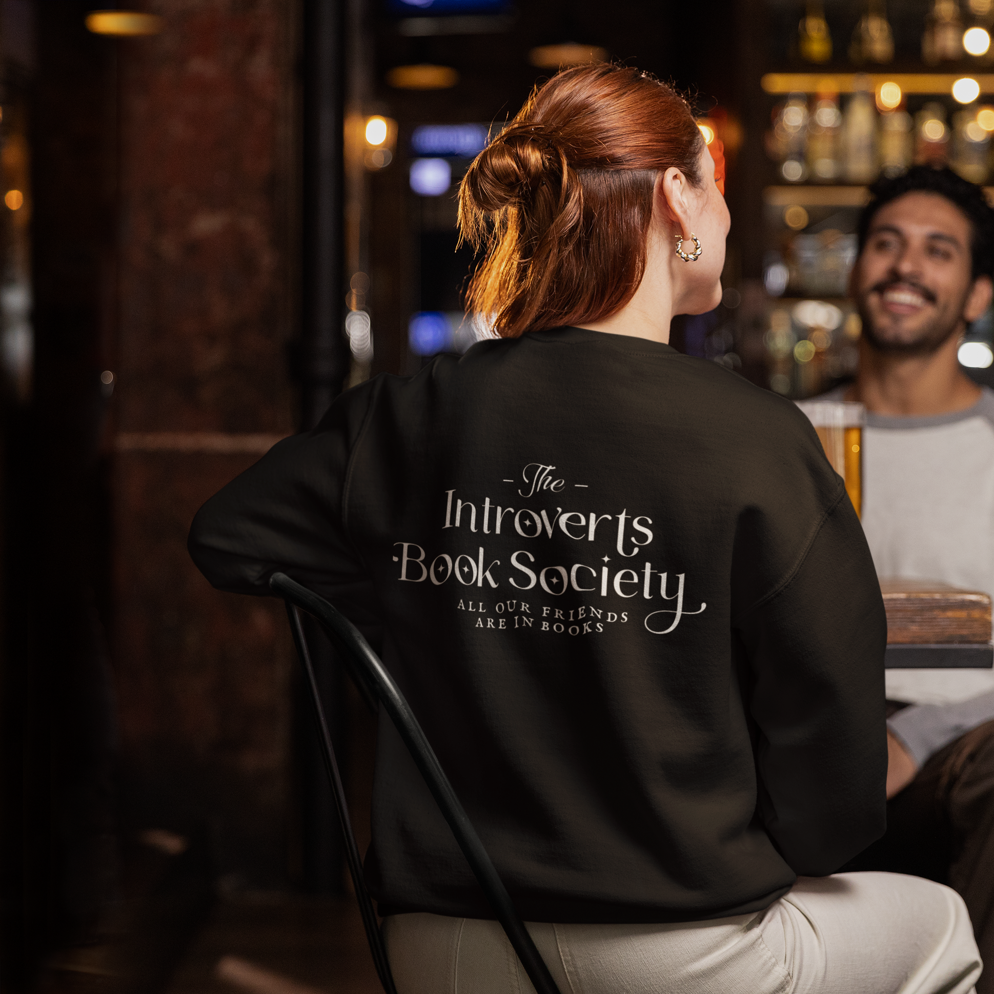 back-view-gildan-sweatshirt-mockup-of-a-woman-sitting-in-a-sports-bar-m38076.png