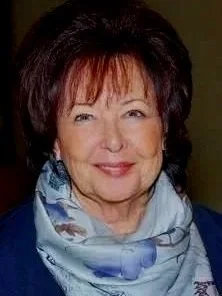 Smiling woman with short, dark hair and a scarf around her neck