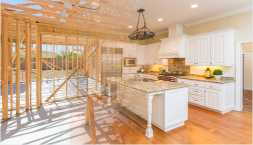 Kitchen with white cabinets and granite countertops, partially under construction with exposed wooden framing and a partially built exterior wall.