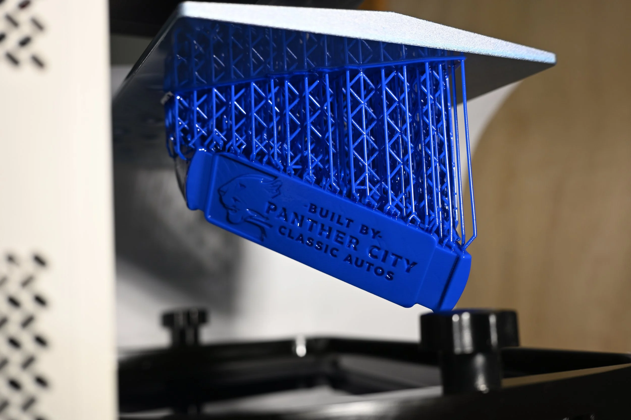 image showing a resin part being held by supports on a 3d printer