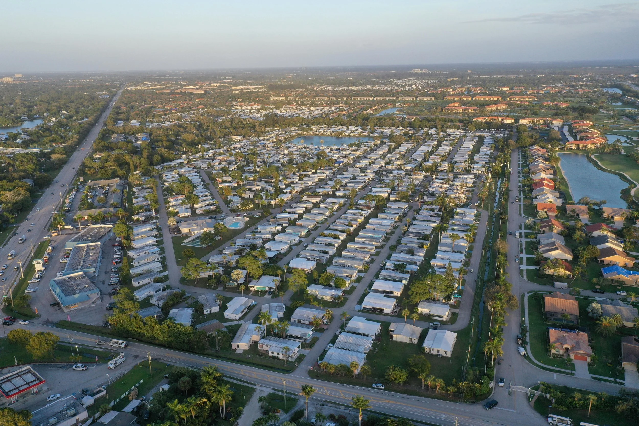 bird view of Florida neighborhood community white roofs and lush green yards