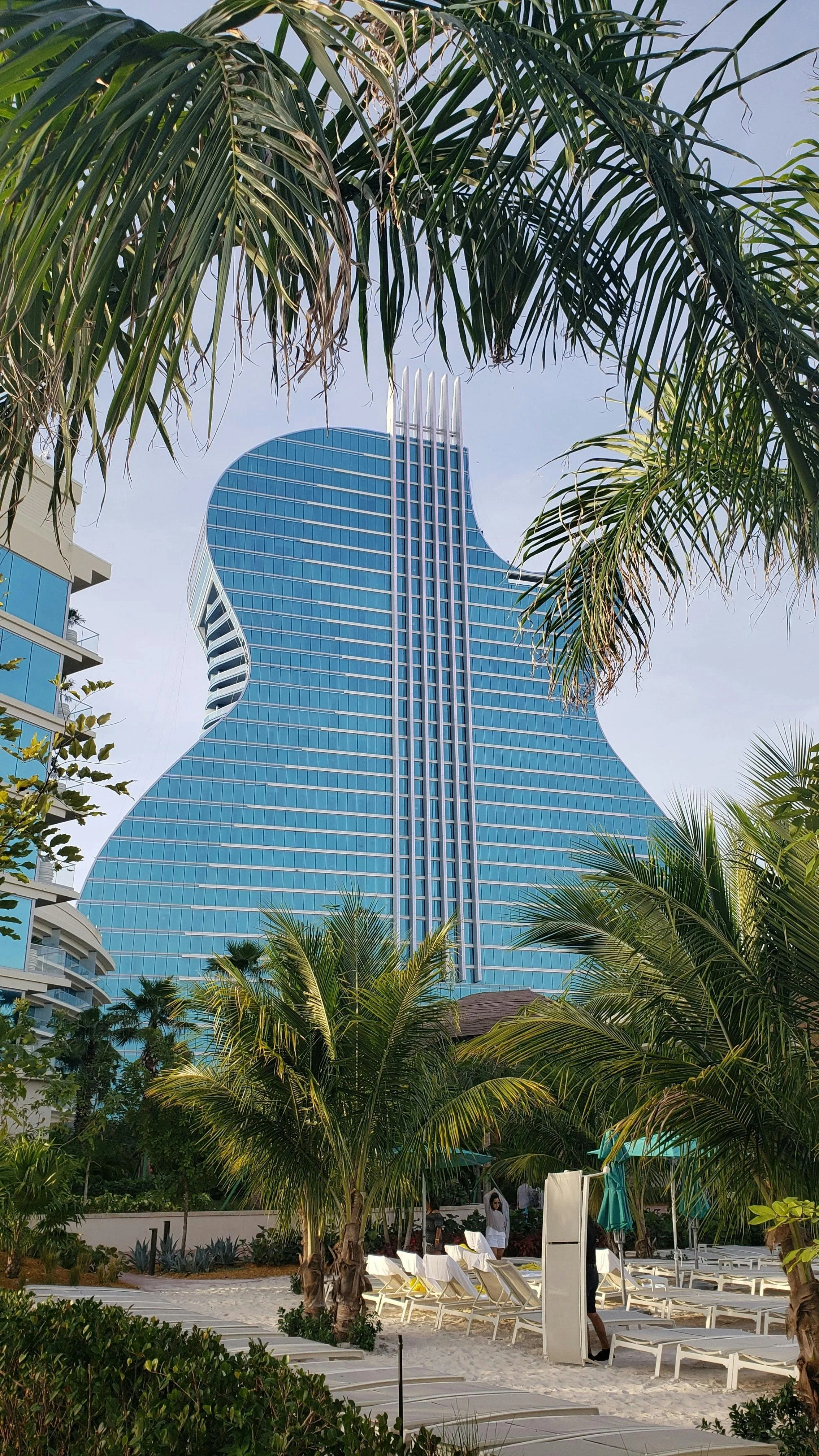 Guitar shaped Hard Rock Cafe Hotel in Florida framed by palm leaves