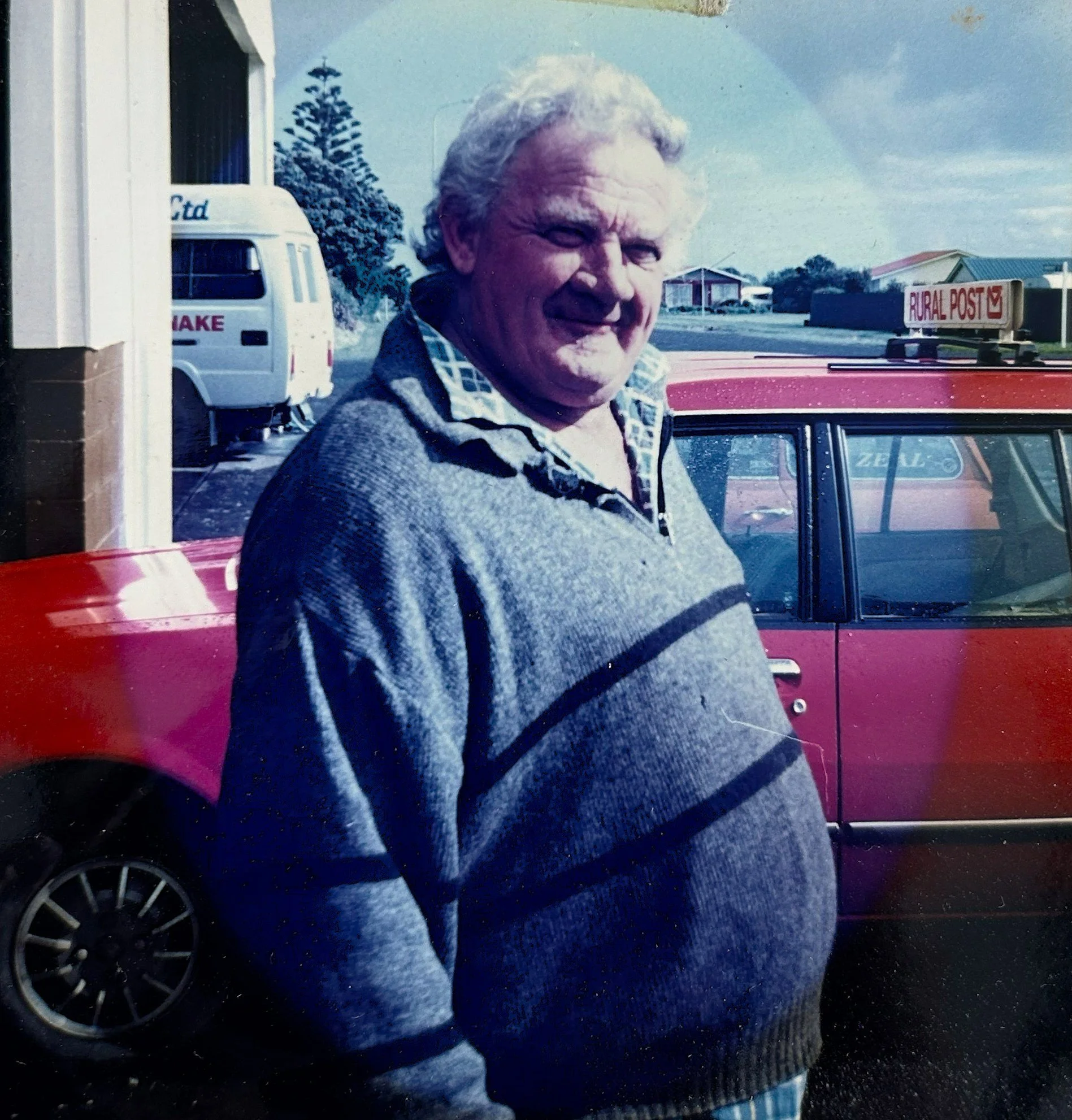 Gerald Pickering standing in front of the depot and red mail car
