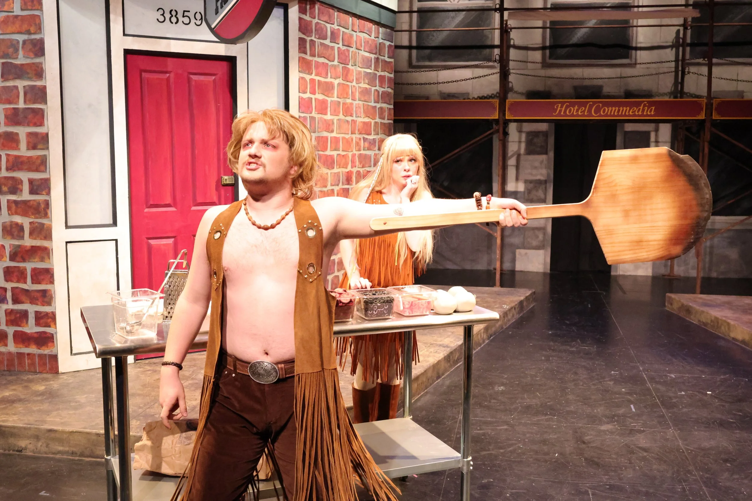 Greg challenges Tricia with a pizza peel