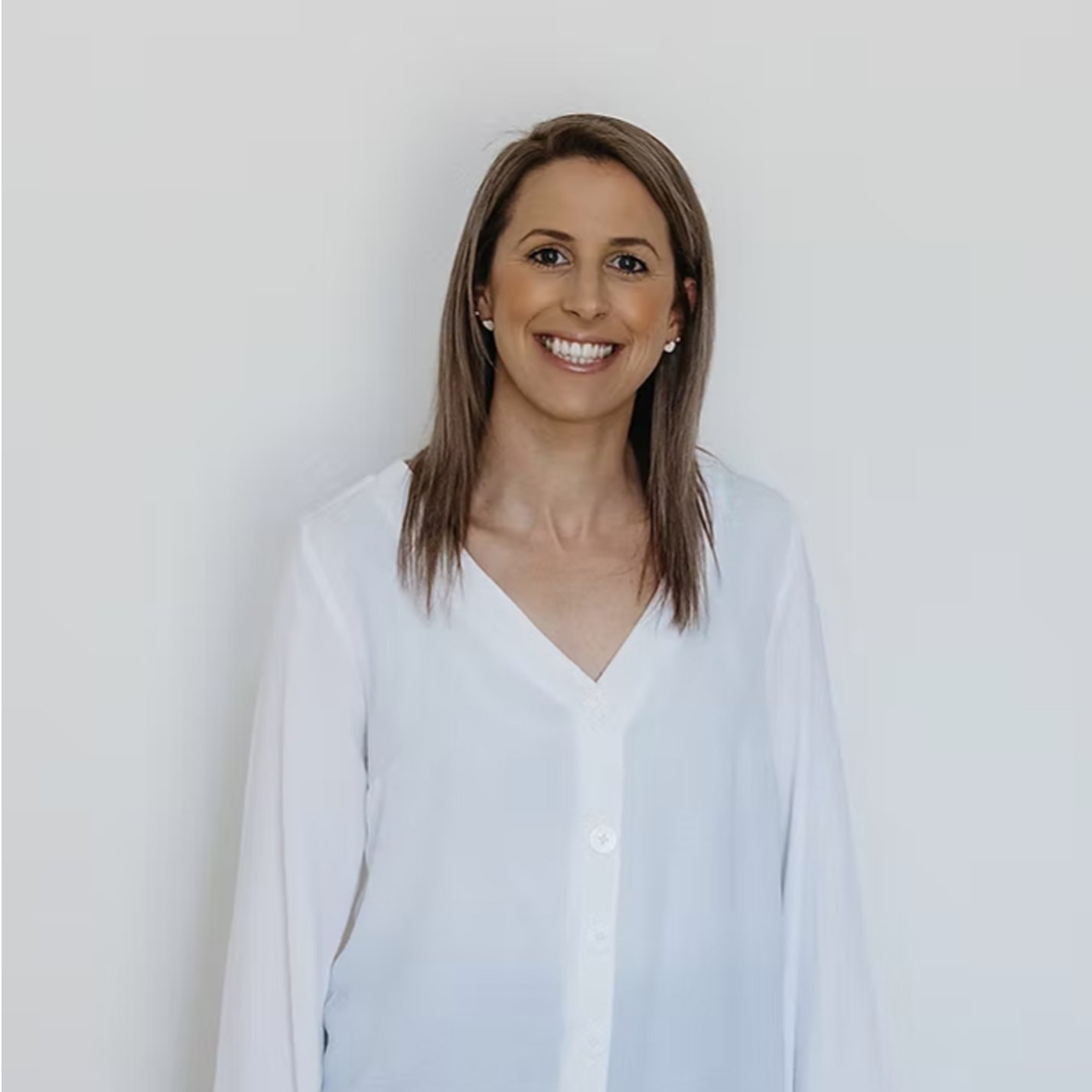 Woman in a white shirt with brunette hair on a white background