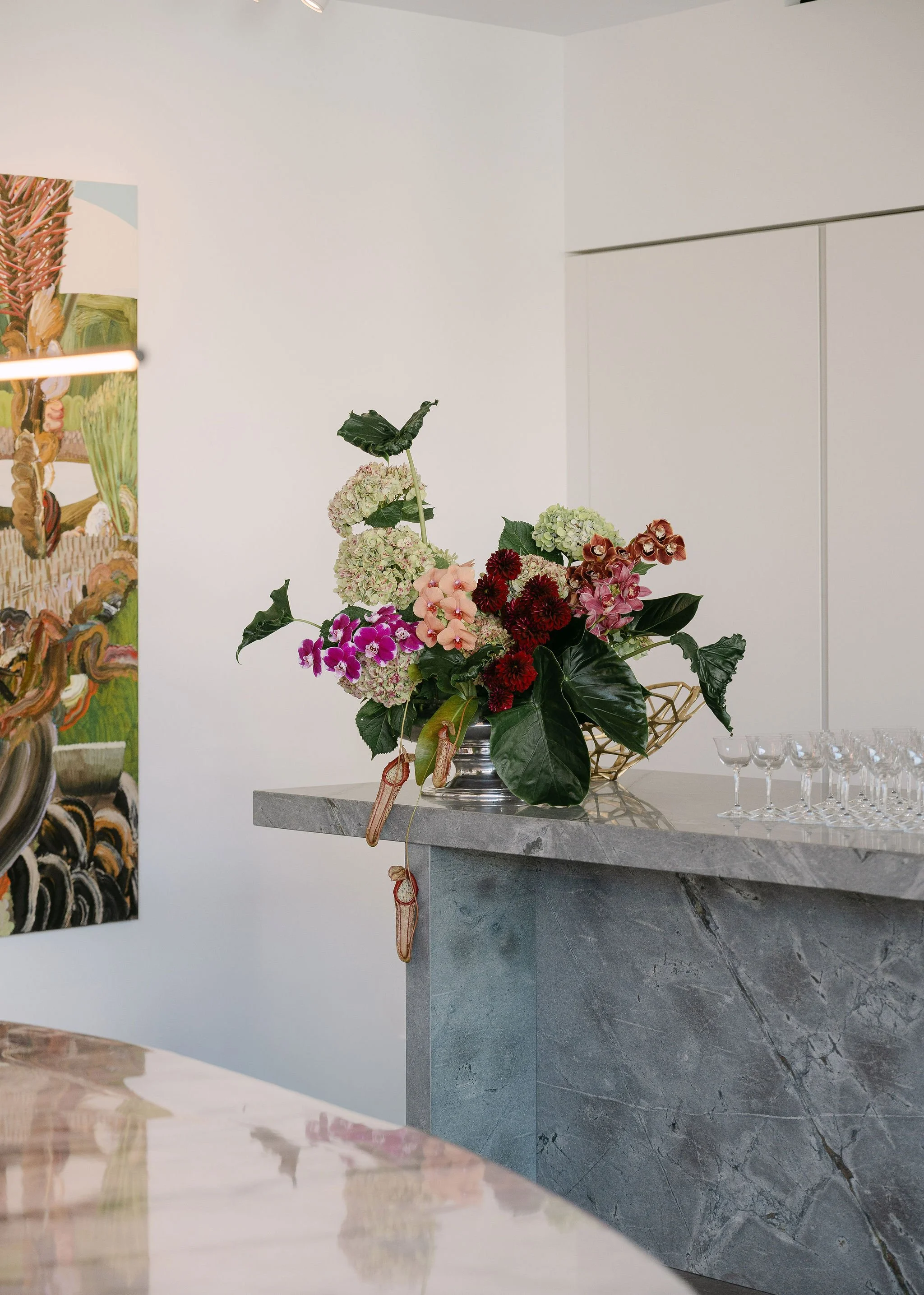 A colorful flower arrangement on a marble counter in a modern interior space.