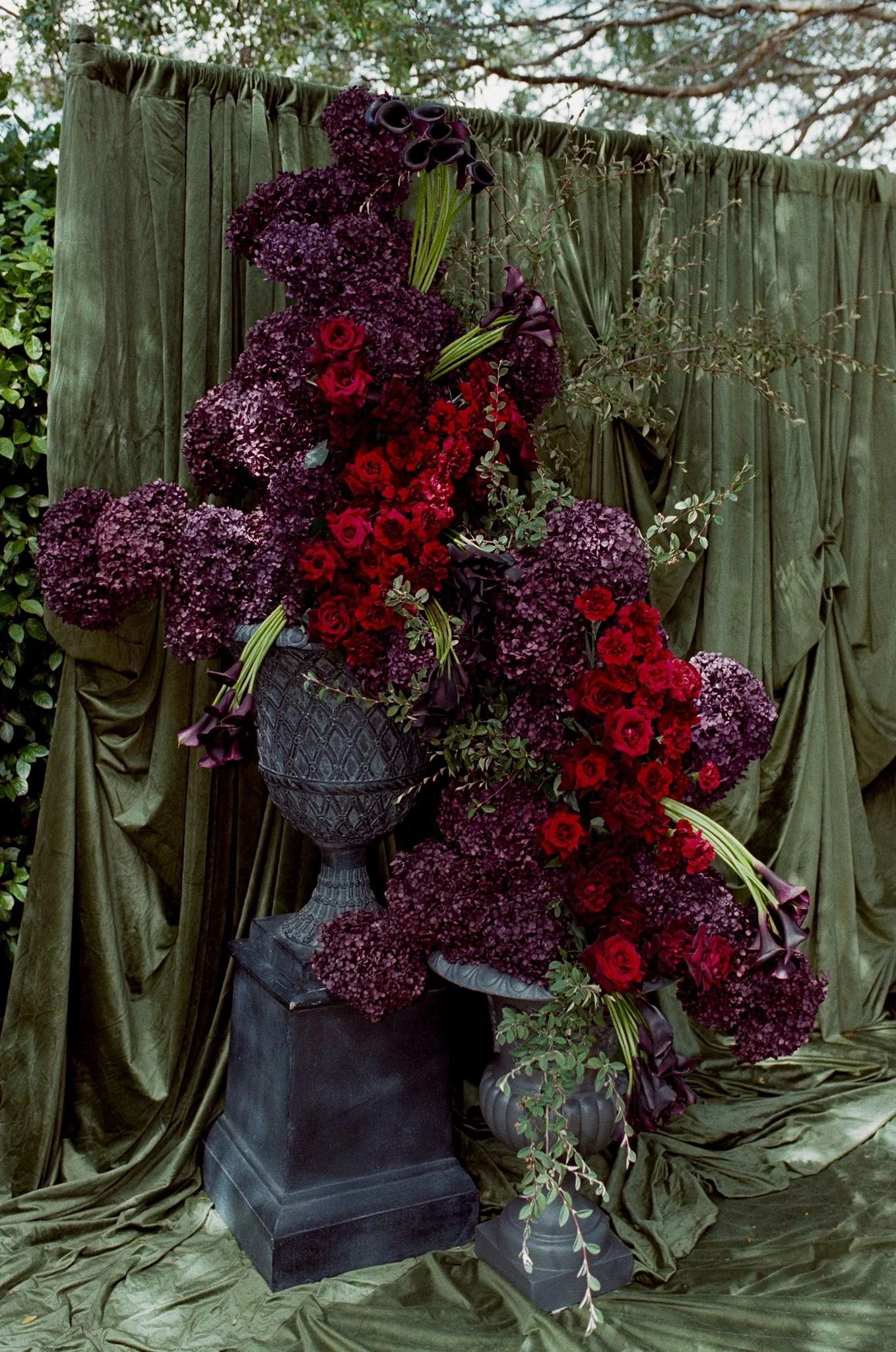 A banquet table decorated with a floral centerpiece, glasses, and utensils, with a panoramic landscape image projected on the fabric walls.