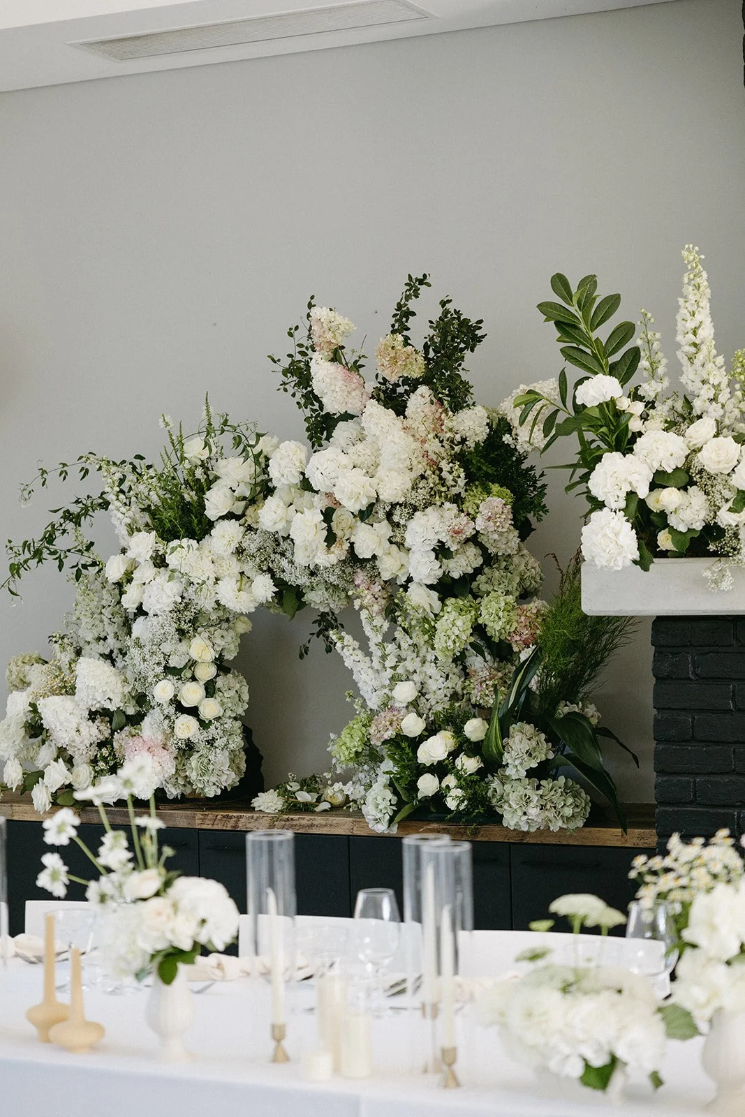 Floral arrangement with white flowers on a table at what appears to be a wedding or event venue.