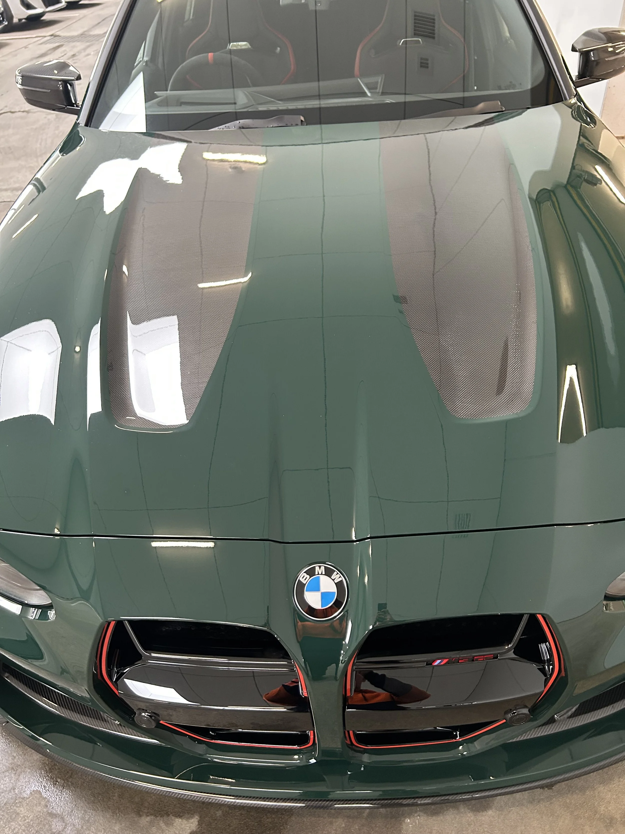 BMW M4 bonnet after paint correction and polish, showing high-gloss reflections on the surface.