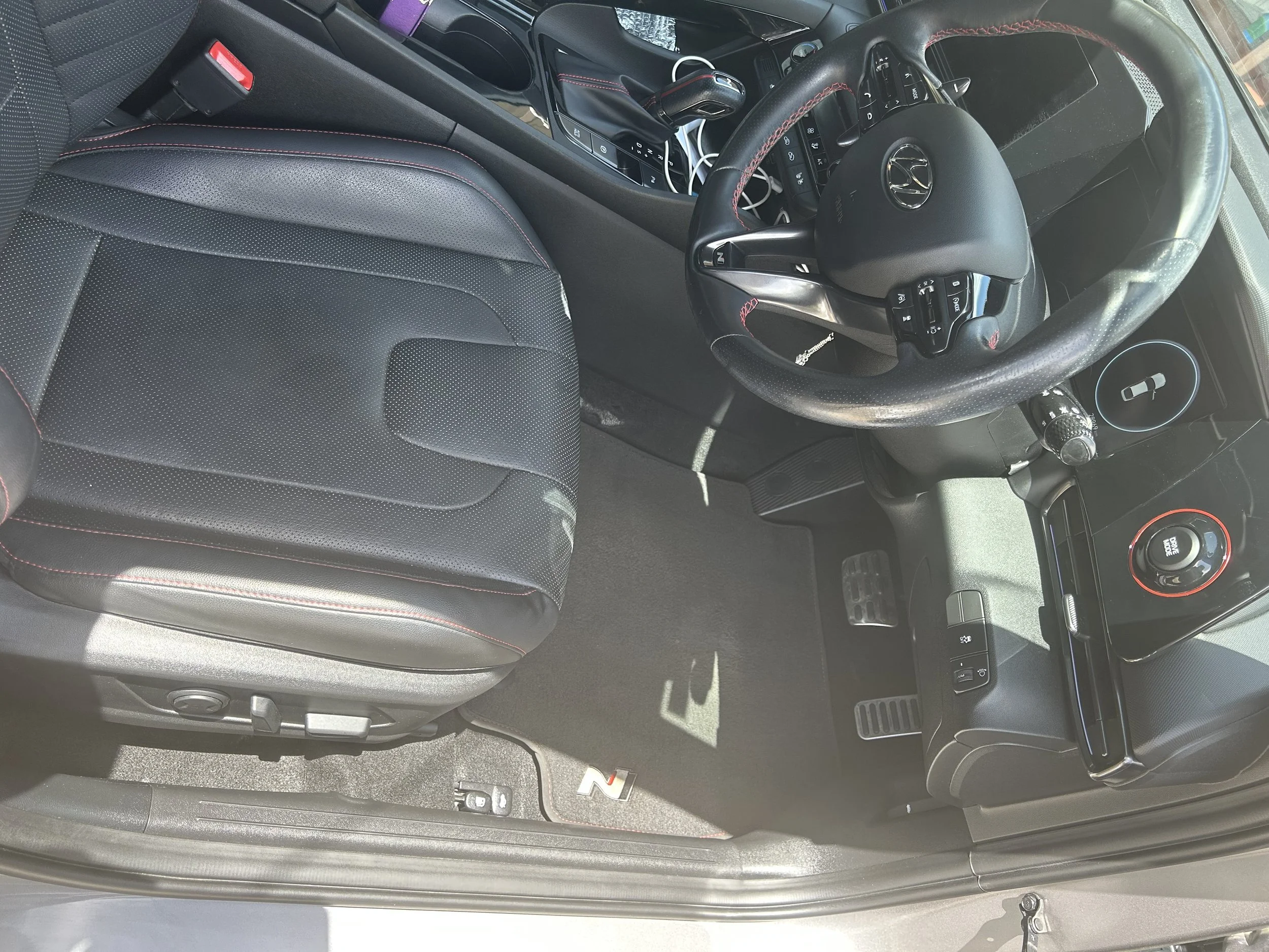 After interior car detail showing clean driver’s seat, polished dashboard, spotless steering wheel, and restored carpets.