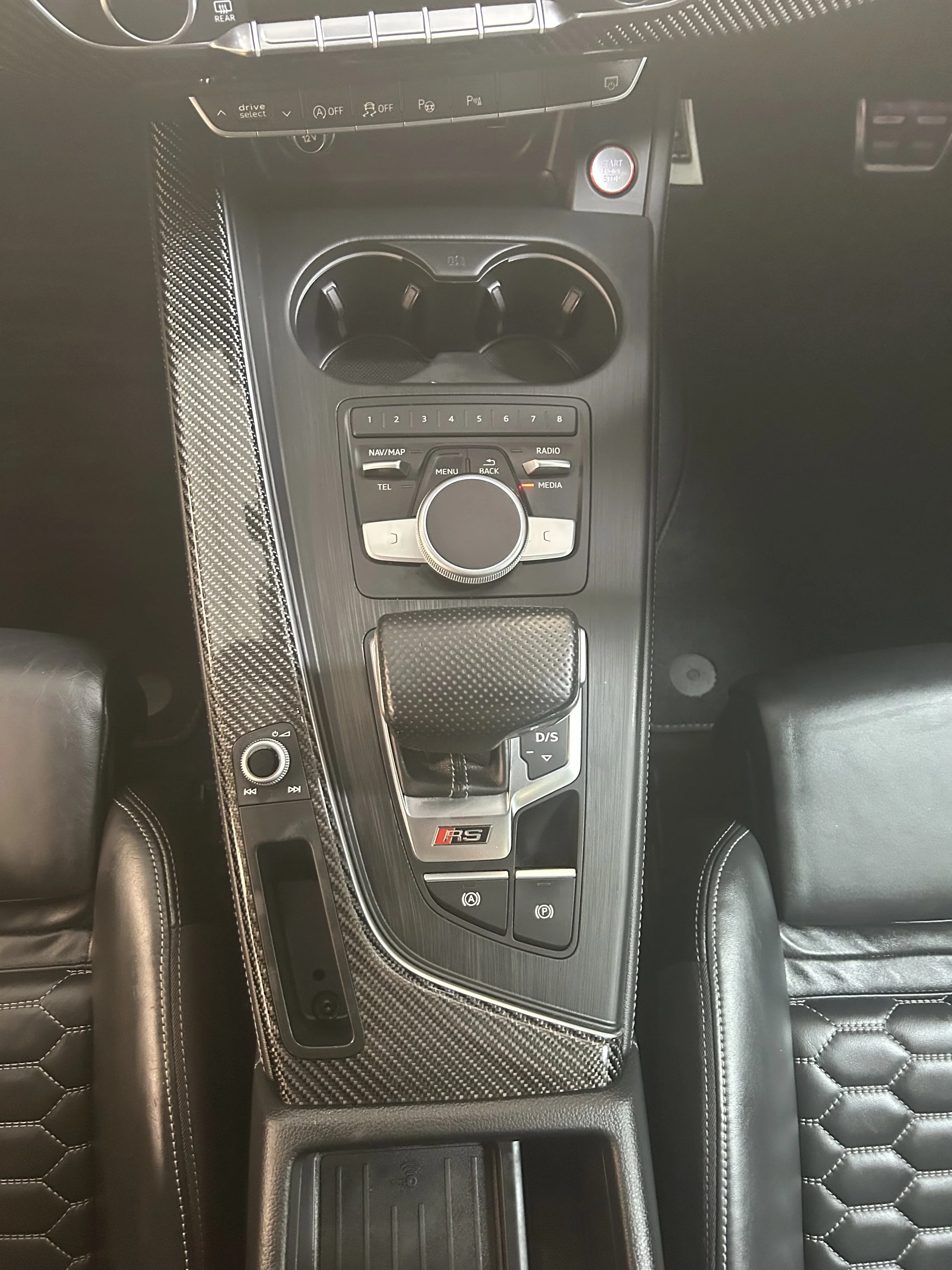 After interior detail – cleaned and restored center console with polished gear shifter, buttons, electronic parking controls, and carbon-fiber trim, showing a refreshed and glossy finish.