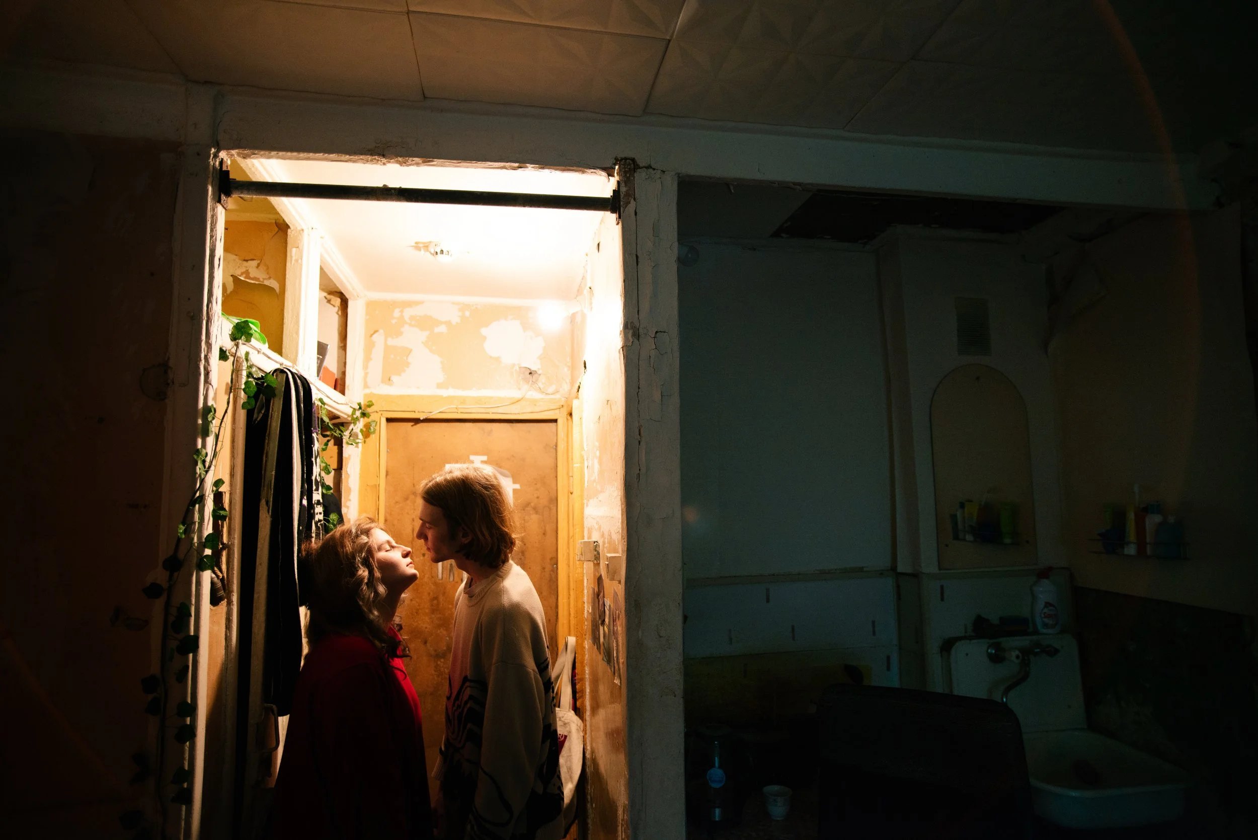 Young couple standing closely together inside a small apartment doorway in post-Soviet Russia. Photograph by Semyon Kokorin featured in “Semyon’s World” by Timofey Abel.