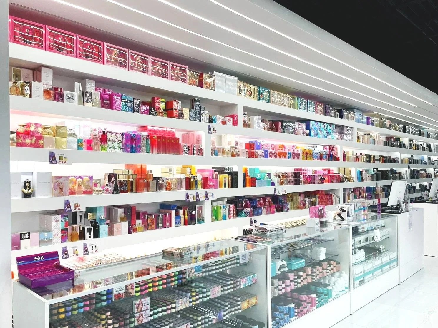 Shelves stocked with a variety of colorful perfumes and fragrance bottles in a retail store.