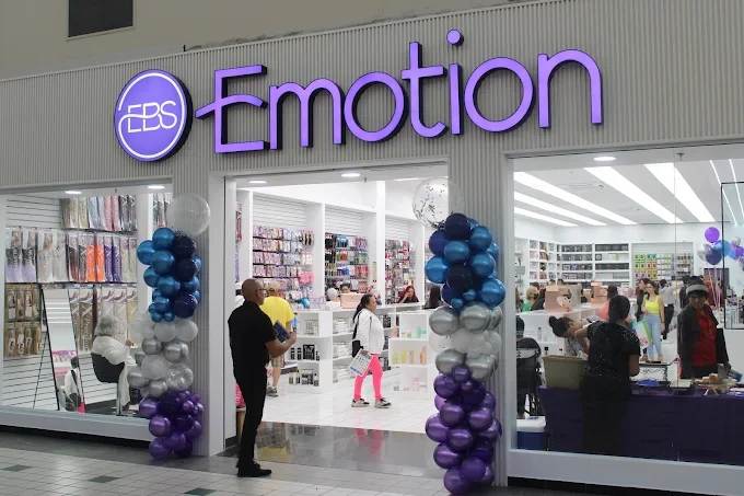 Store entrance with purple and silver balloon decorations, purple sign that reads 'EBS Emotion,' and shoppers inside browsing products.