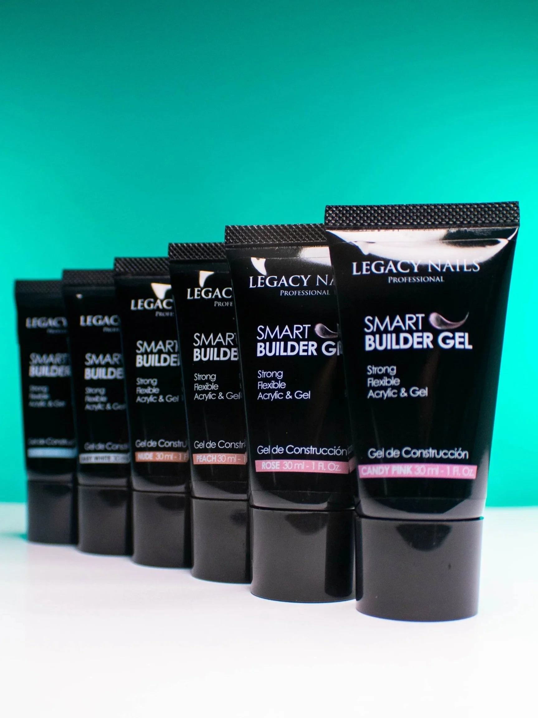 Six tubes of Legacy Nails Smart Builder Gel in different shades, including Peach, Rose, and Candy Pink, arranged in a row against a gradient teal and black background.