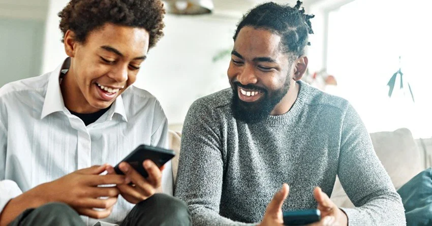 A father and son are excited during online orientation.