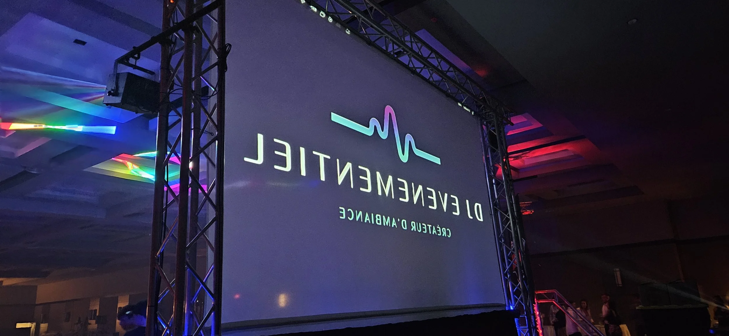 Projection sur un écran d'une conférence ou événement Médical intitulé 'De l'évidence' avec un graphique de ligne représentant un cœur, et des couleurs néon sur la pièce.