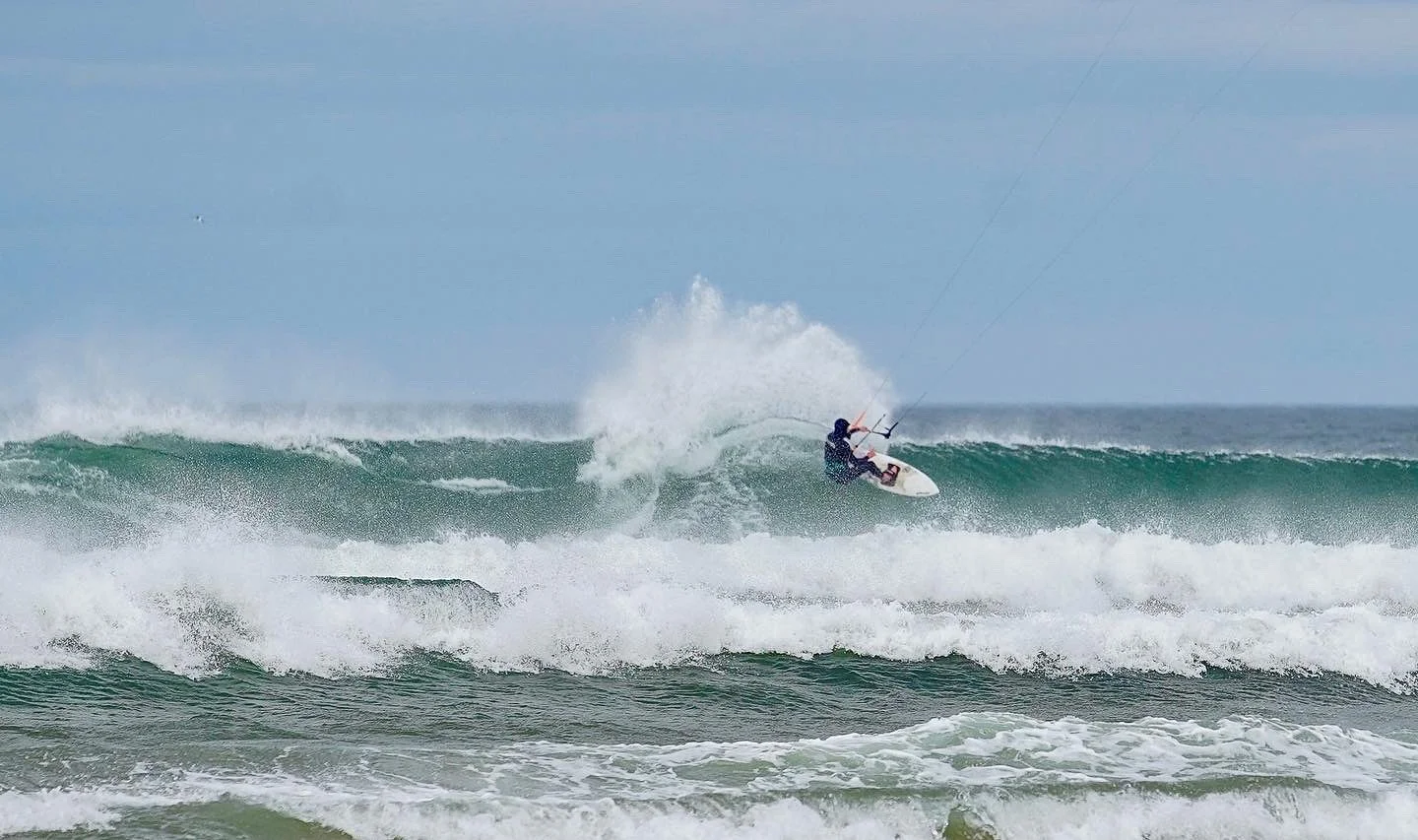 Kite surfer riding a wave on the ocean.