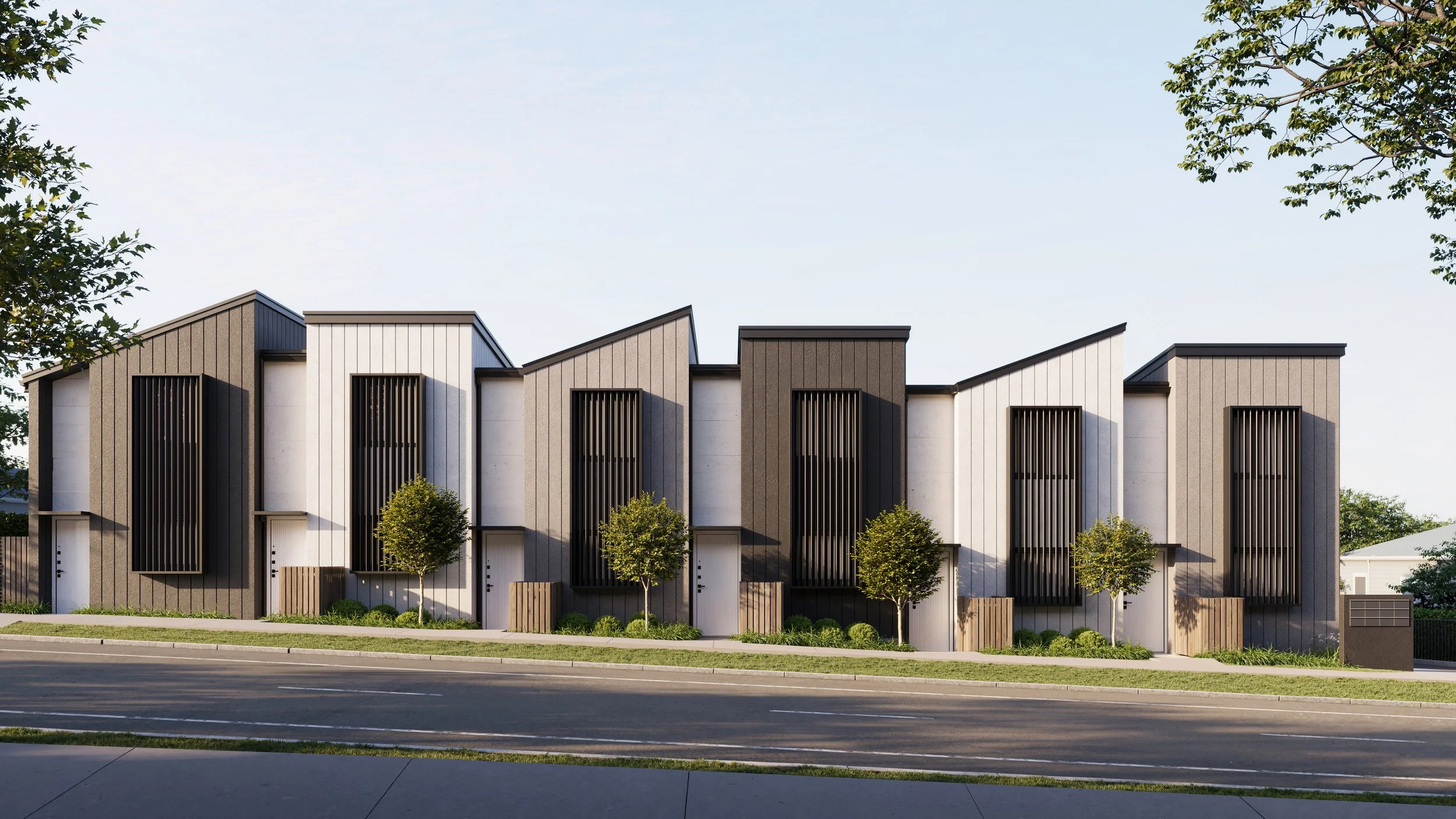 Modern residential row houses in Northgate Estate, New Plymouth, with angular rooflines, vertical wooden slats on windows, and front yard landscaping with small trees and shrubs.