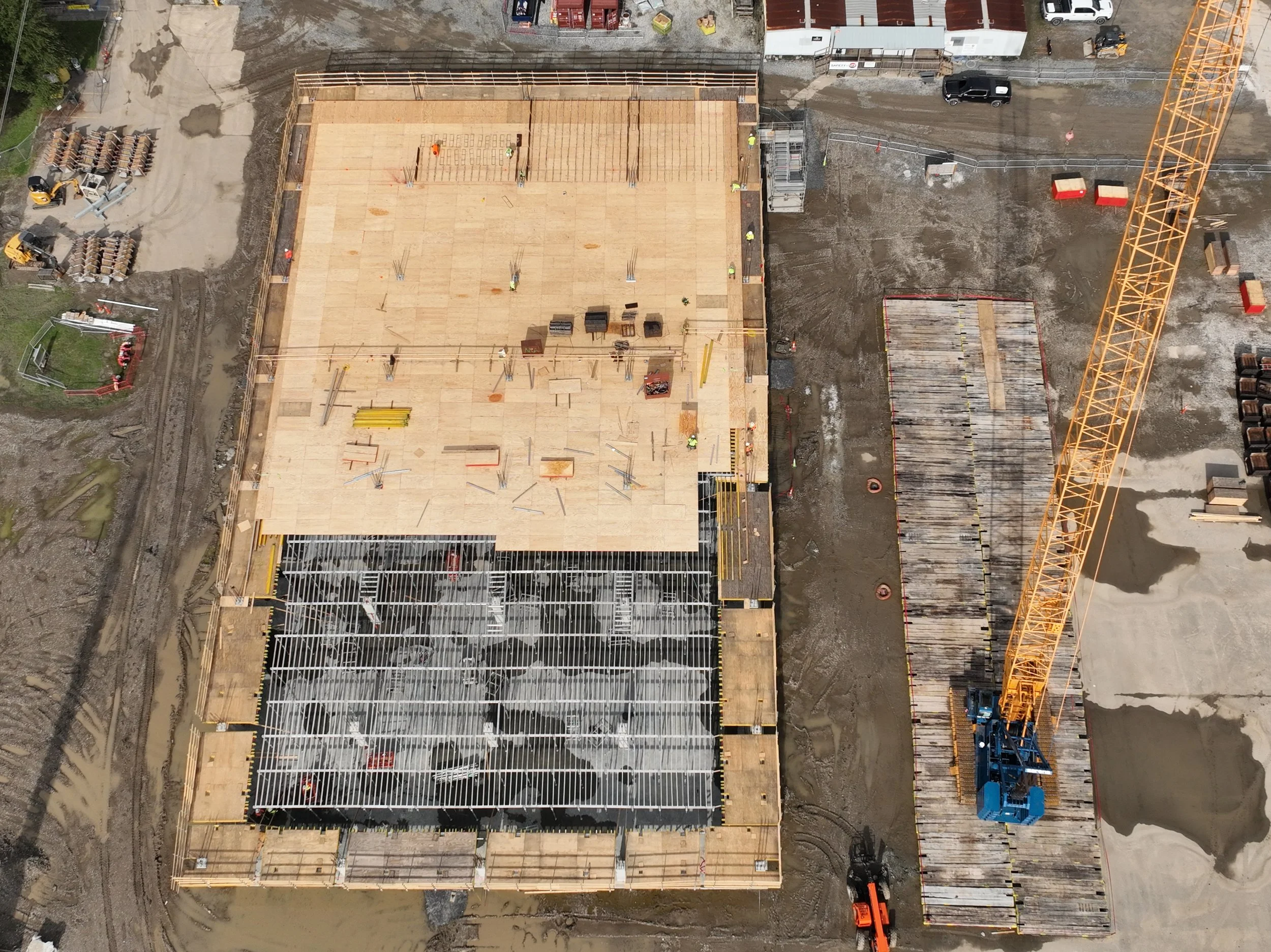 Aerial view of two tugboats undergoing maintenance in a dry dock at a Louisiana shipyard, including vessels labeled Ingram Barge Co. and Pointe à la Hache. Bollinger Shipyards