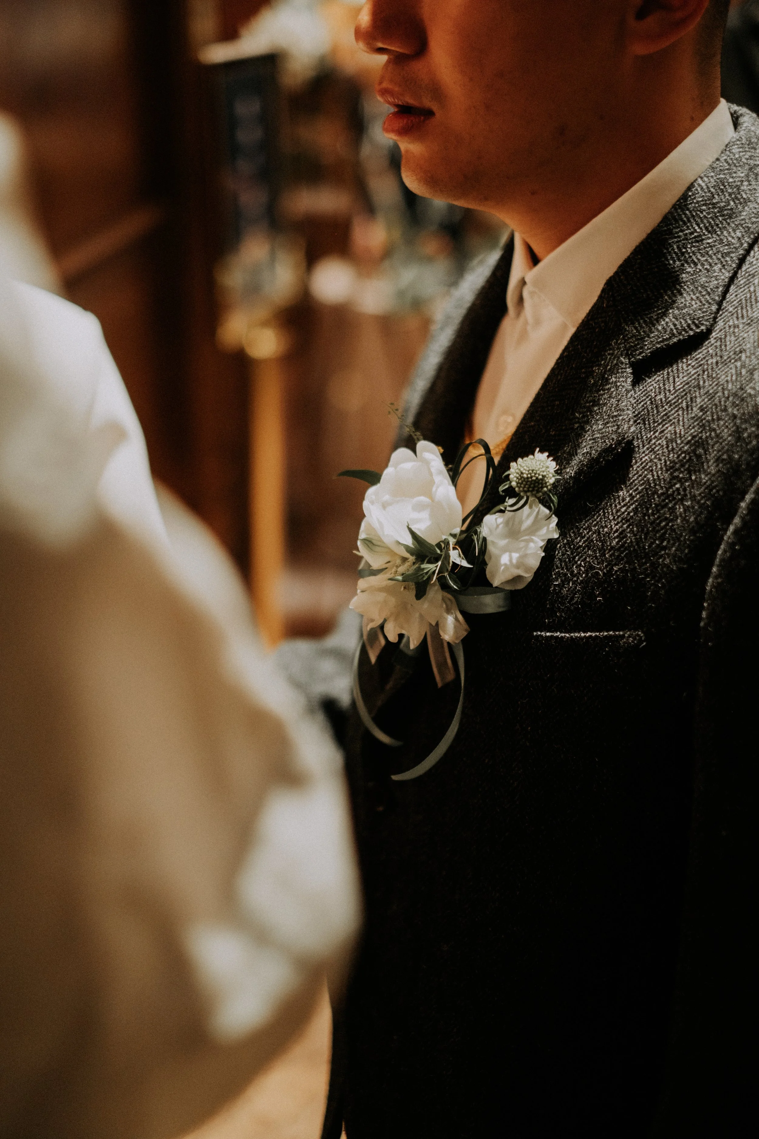 婚禮細節｜新郎胸花特寫，白色花朵搭配深色西裝，儀式感滿滿