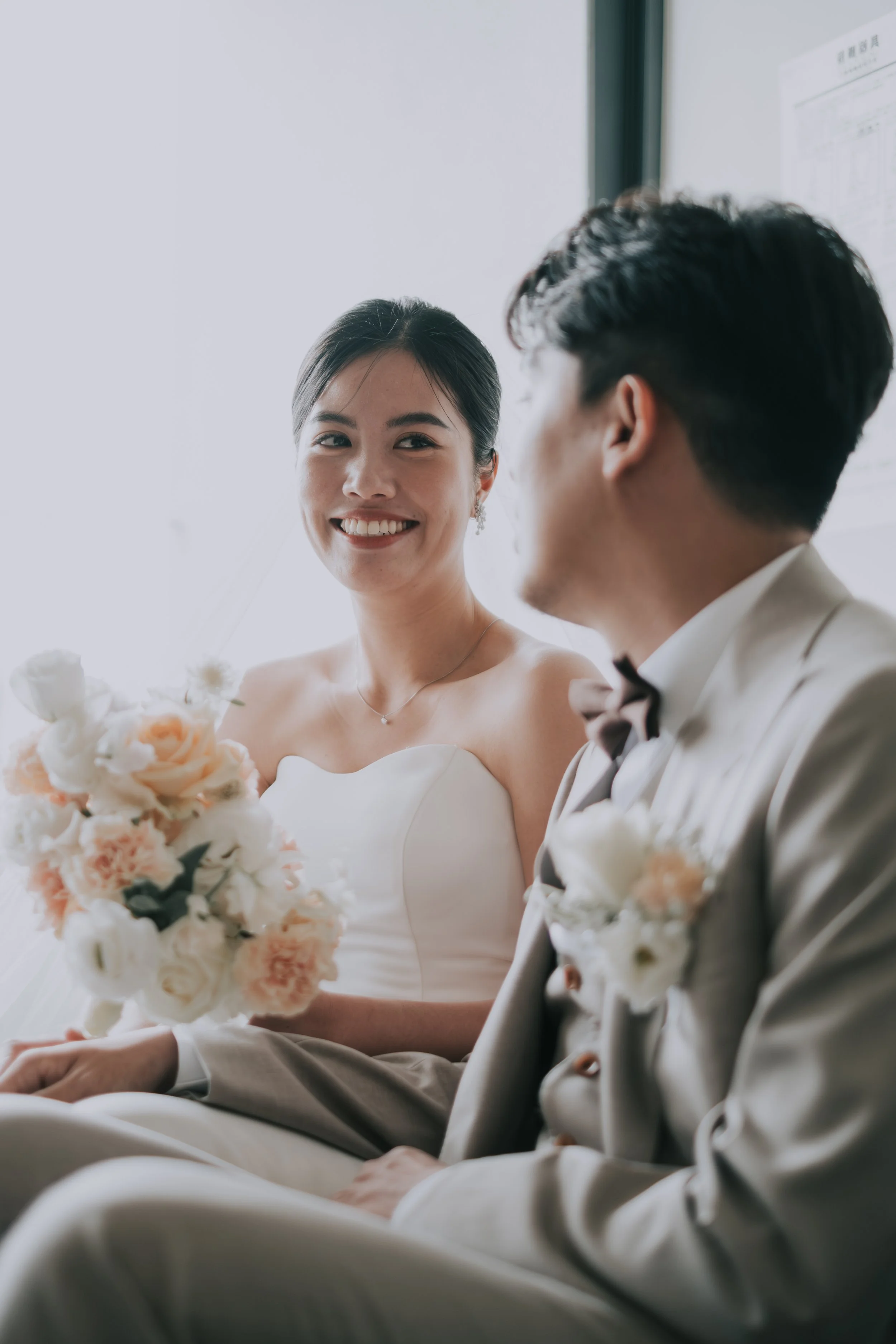 婚紗攝影｜新娘燦爛笑容搭配手捧花，新郎在一旁深情凝望的自然瞬間