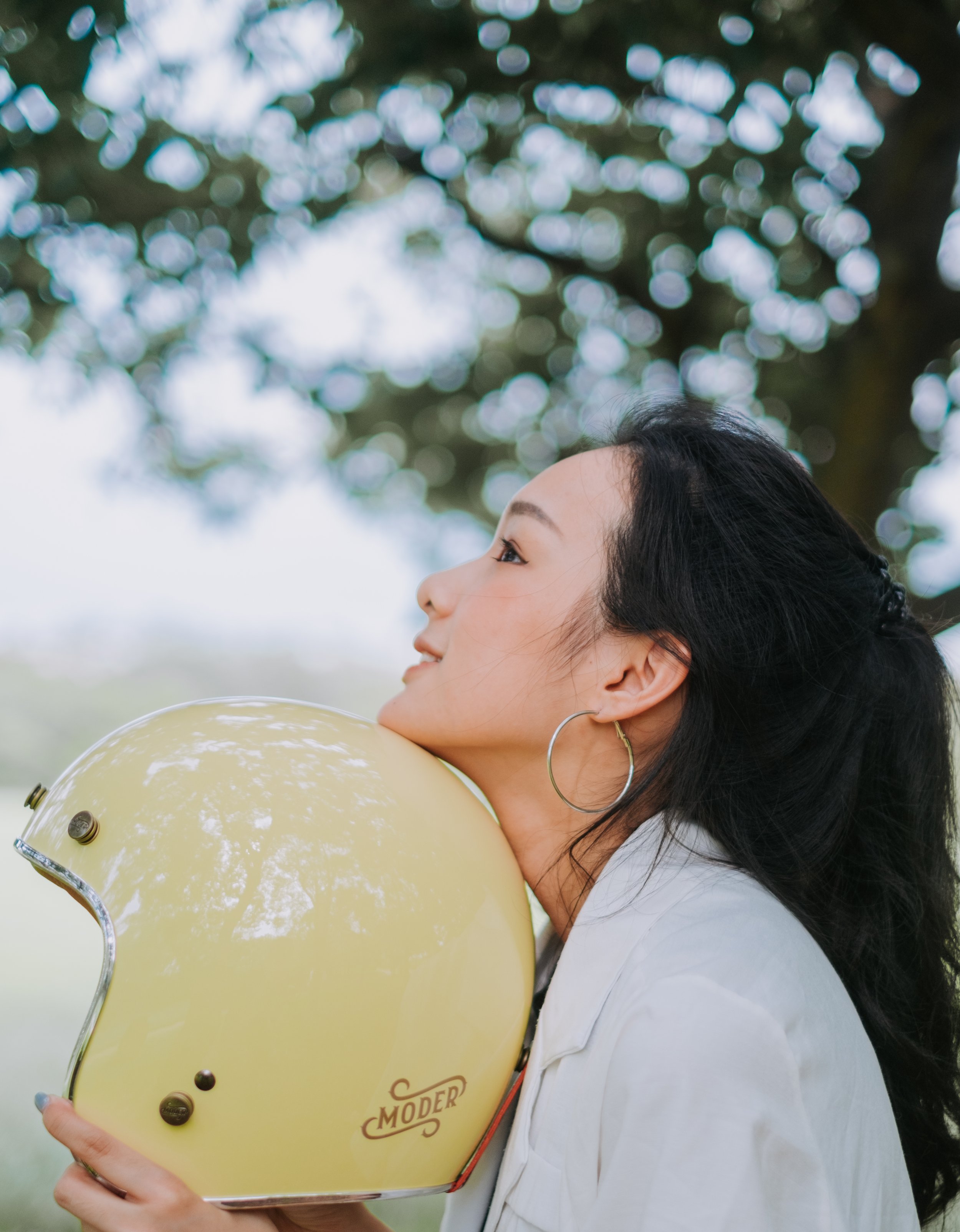 商業攝影｜女生側臉仰望懷抱黃色安全帽，戶外自然光品牌形象寫真拍攝